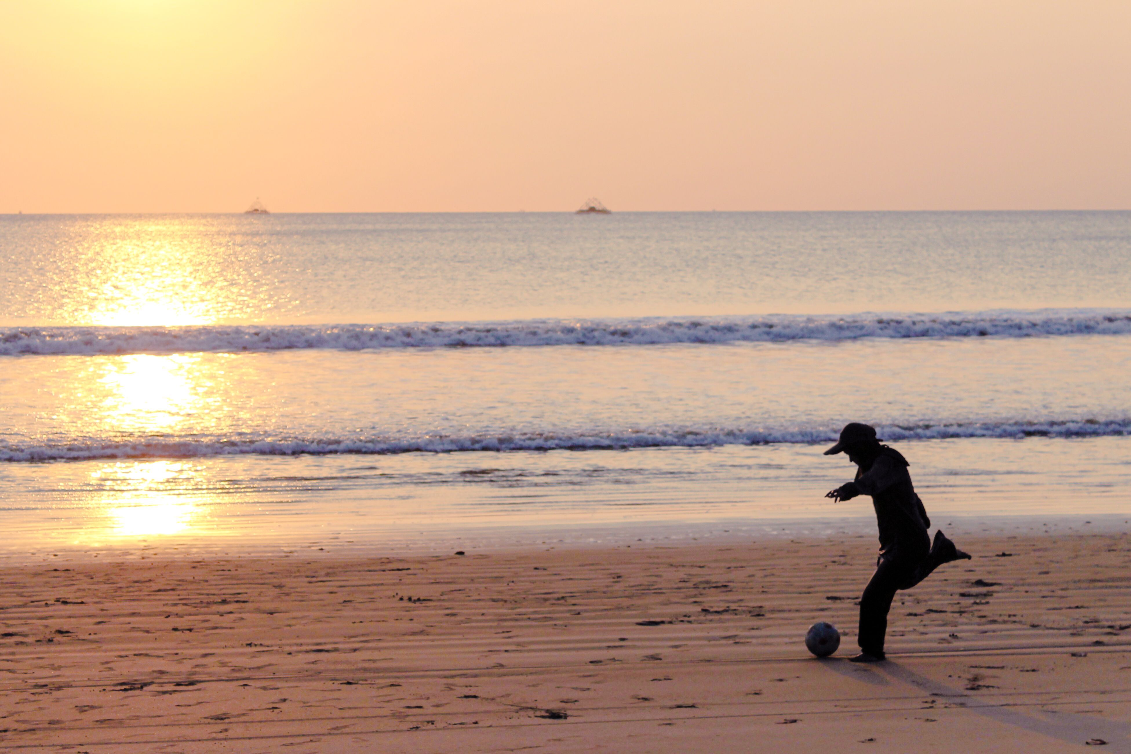 3903x2602 Silhouette of Child Playing Soccer at Beach Sunset · Free