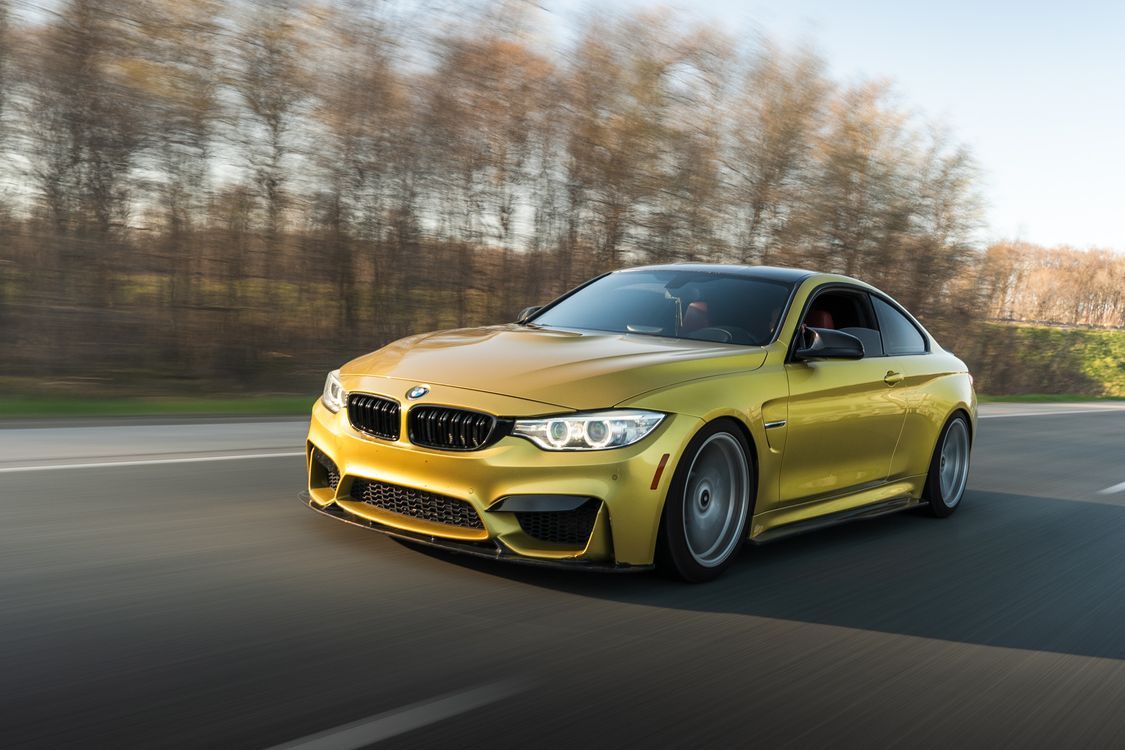 1125x750 Speeding Gold Sports Car on Scenic Drive · Free