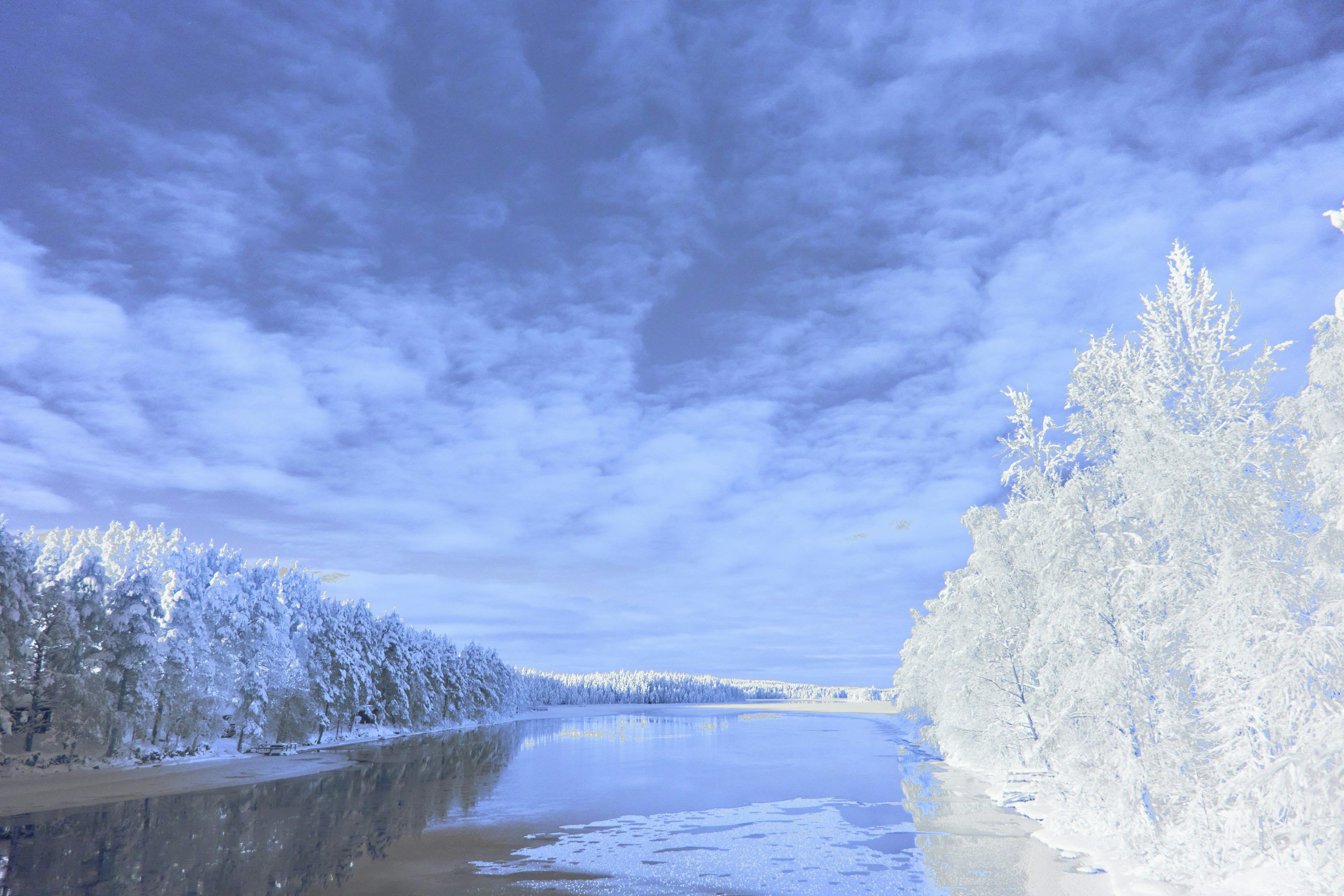 3000x2000 Icy River Flowing Through A Snow Covered Forest Under Cloudy Sky
