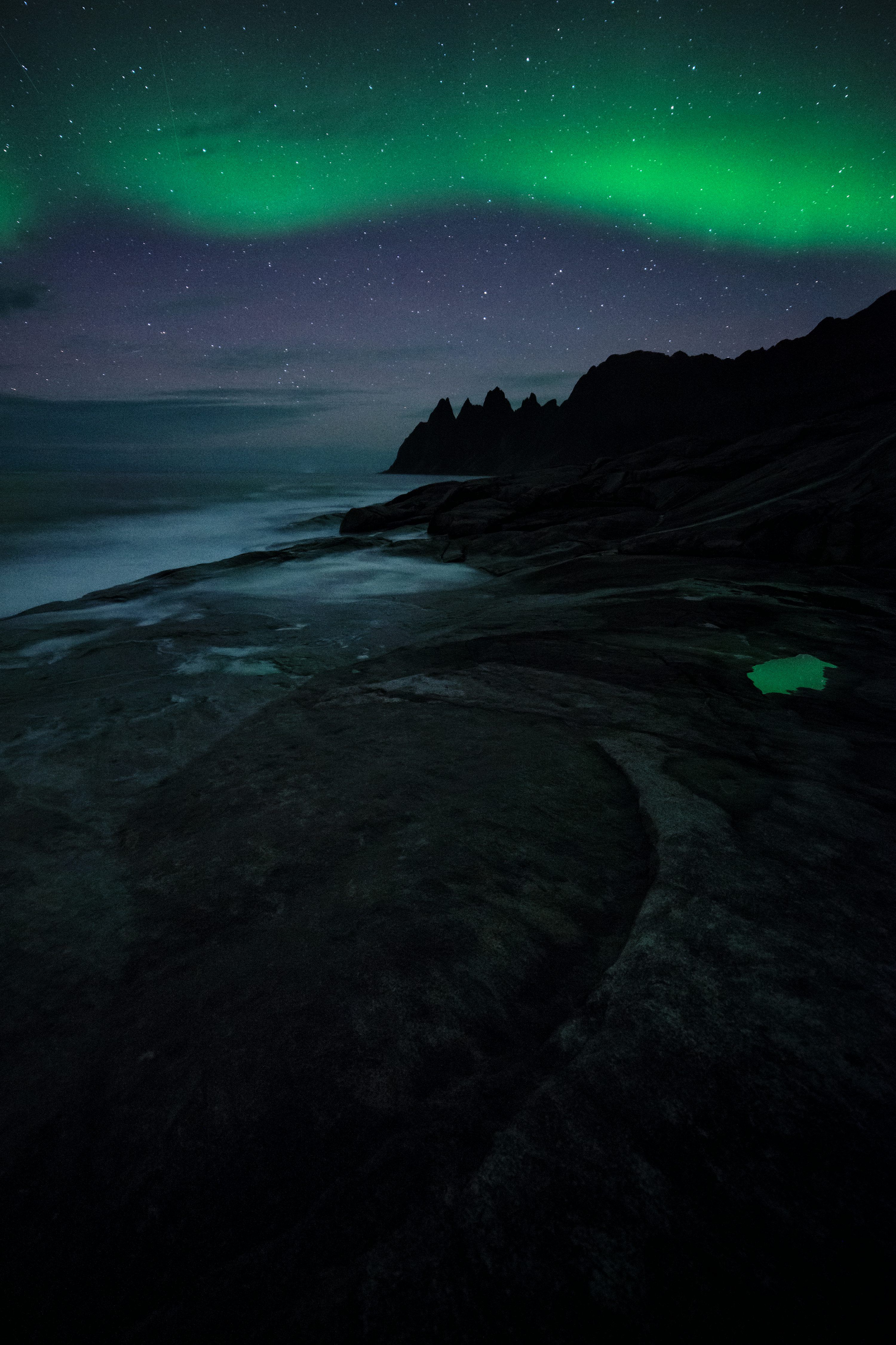 3000x4501 A green and black aurora over a body of water