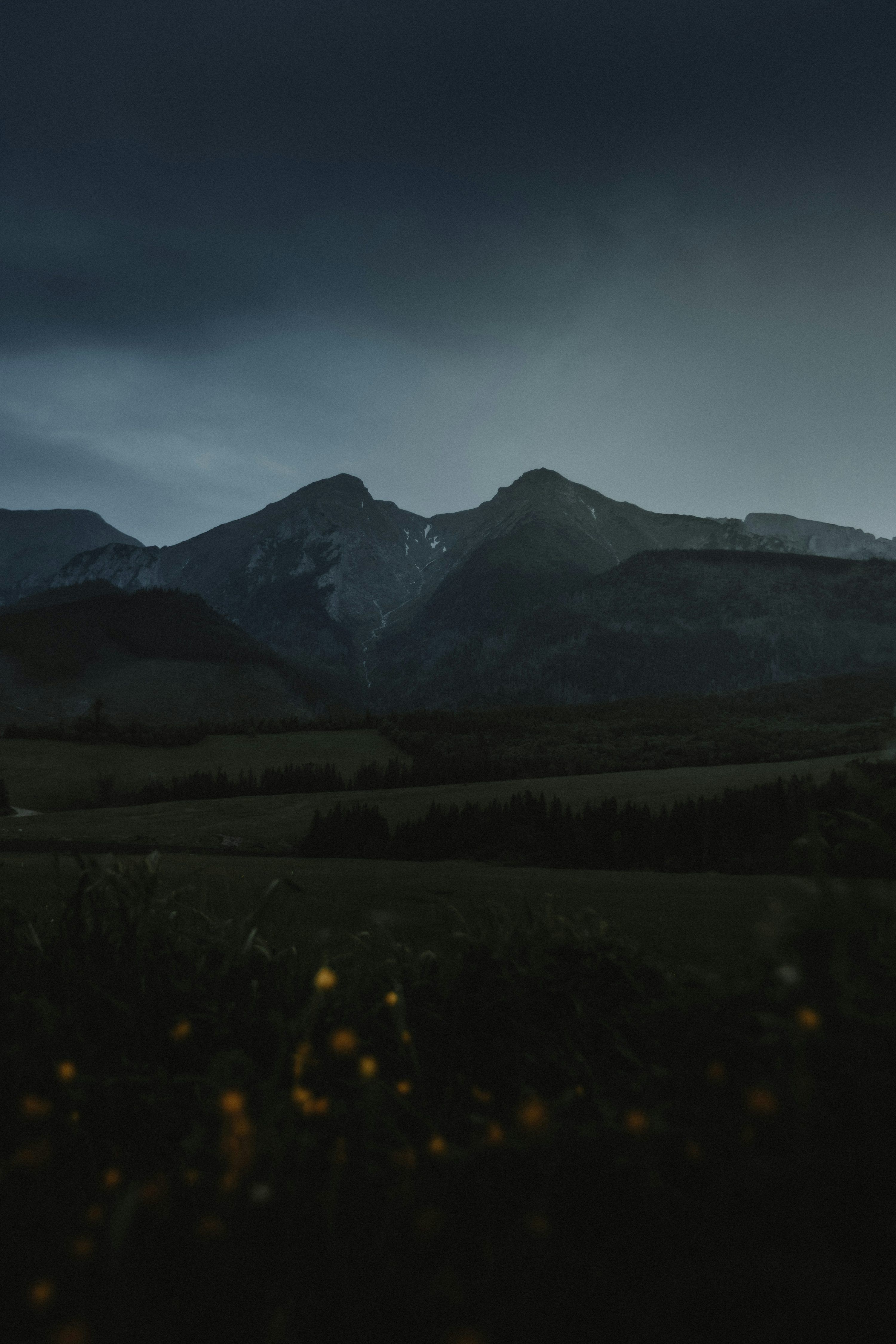 3000x4500 Mountains loom under a dark and stormy sky
