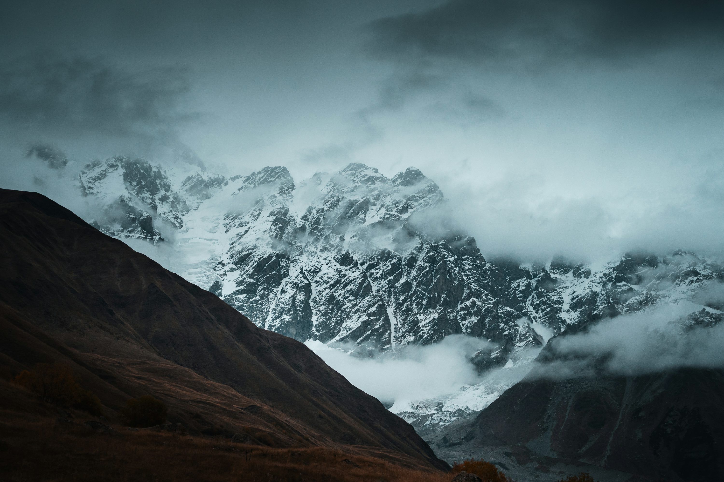 3000x2000 Snowy mountains loom large under stormy skies