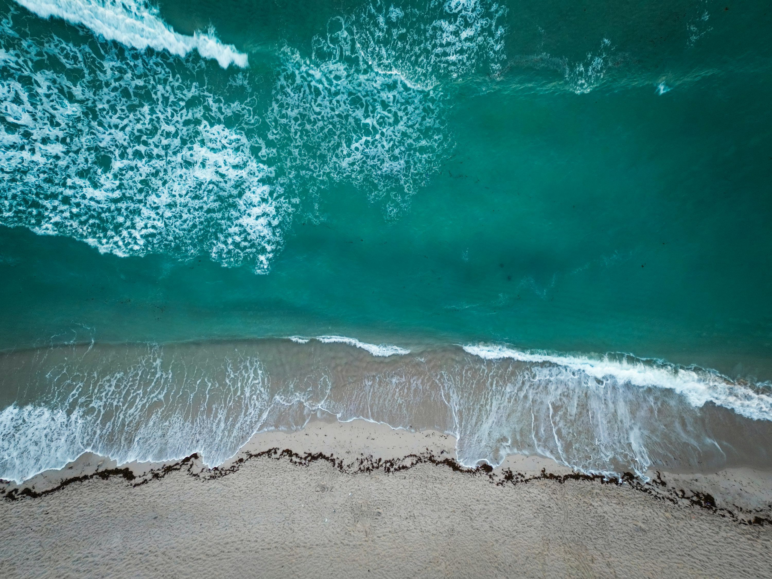 3000x2250 Aerial view of ocean waves crashing onto a sandy beach