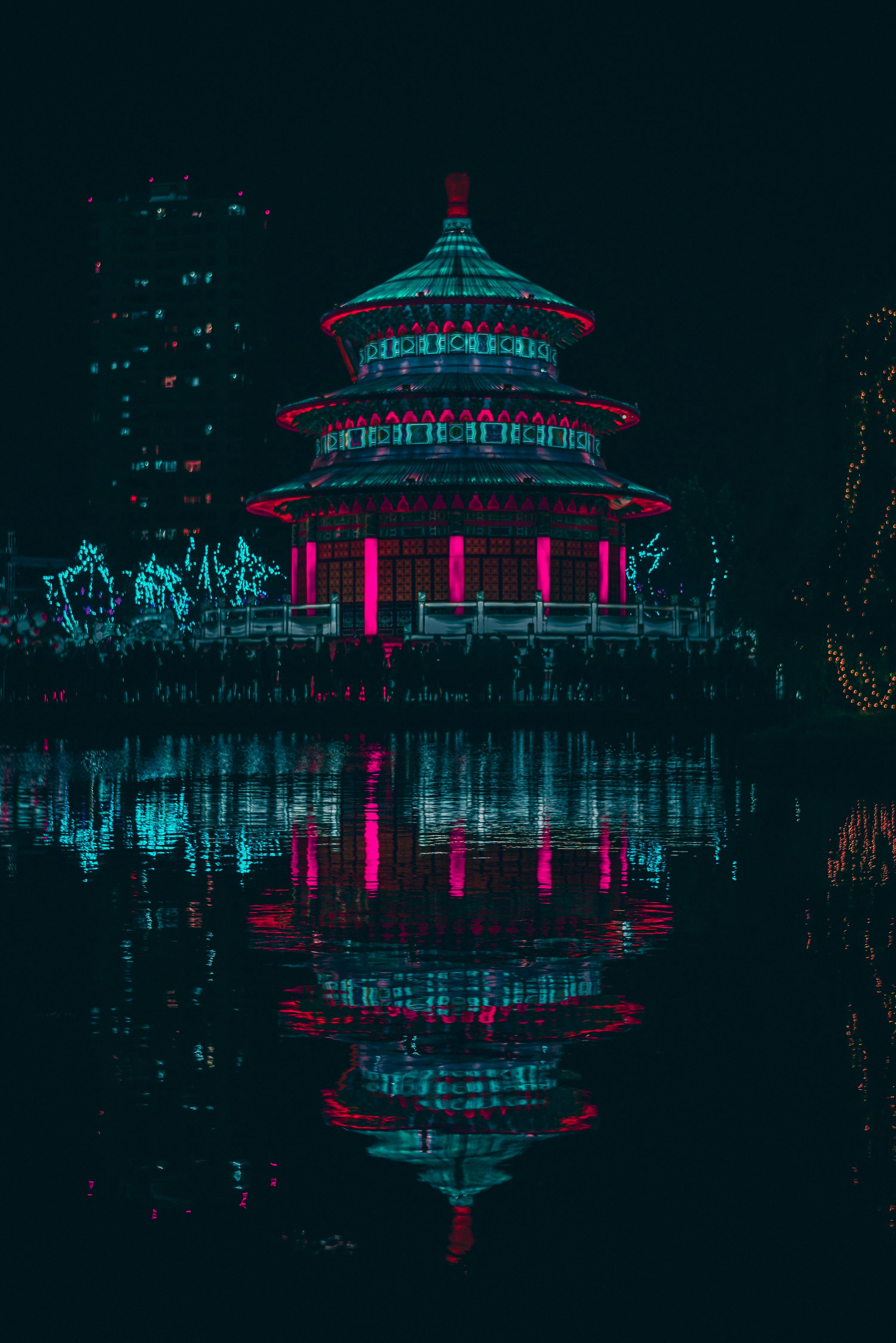 3000x4495 Green and red lighted building near body of water during night time