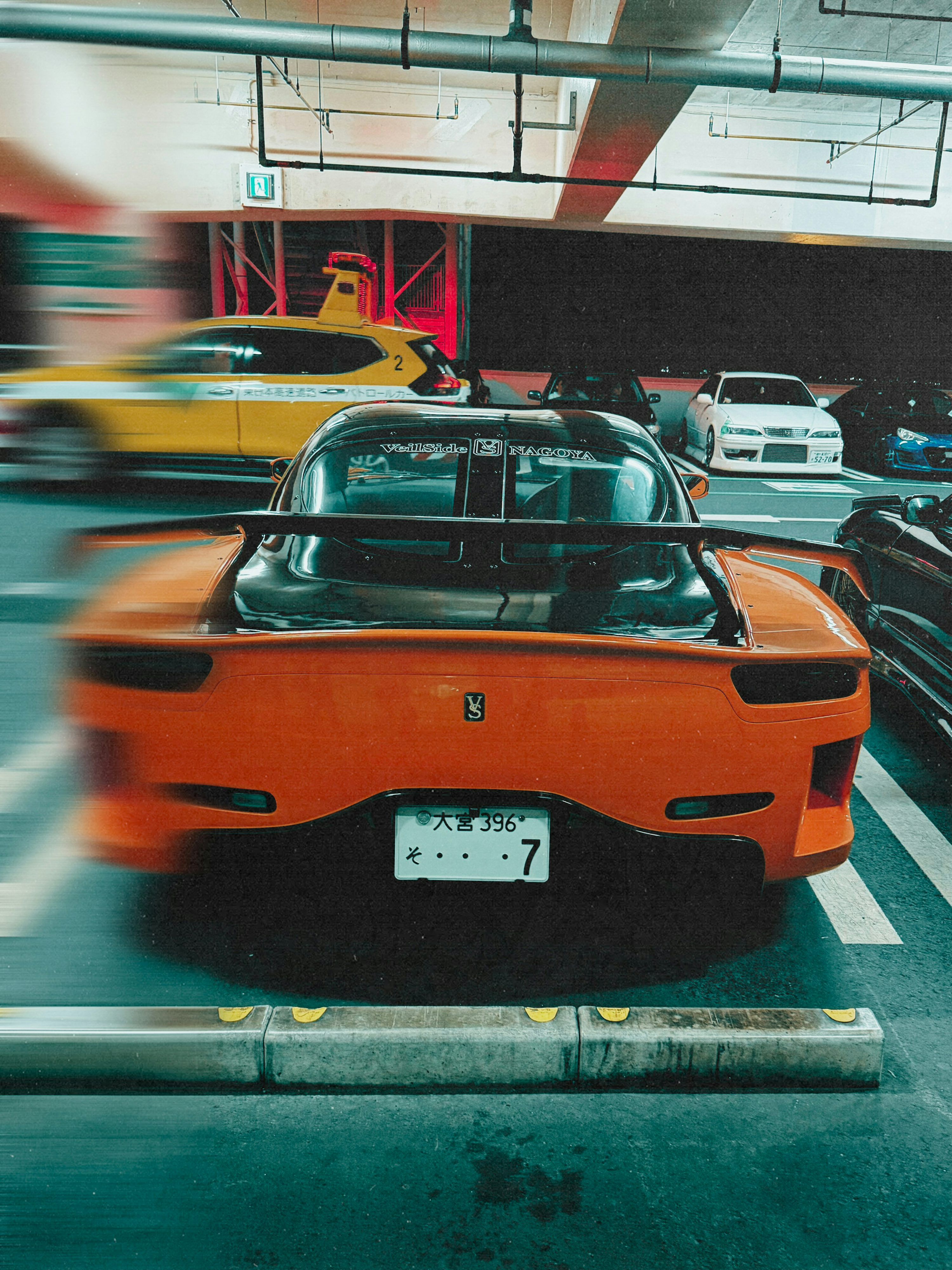 3000x4001 Orange sports car parked in a garage with motion blur