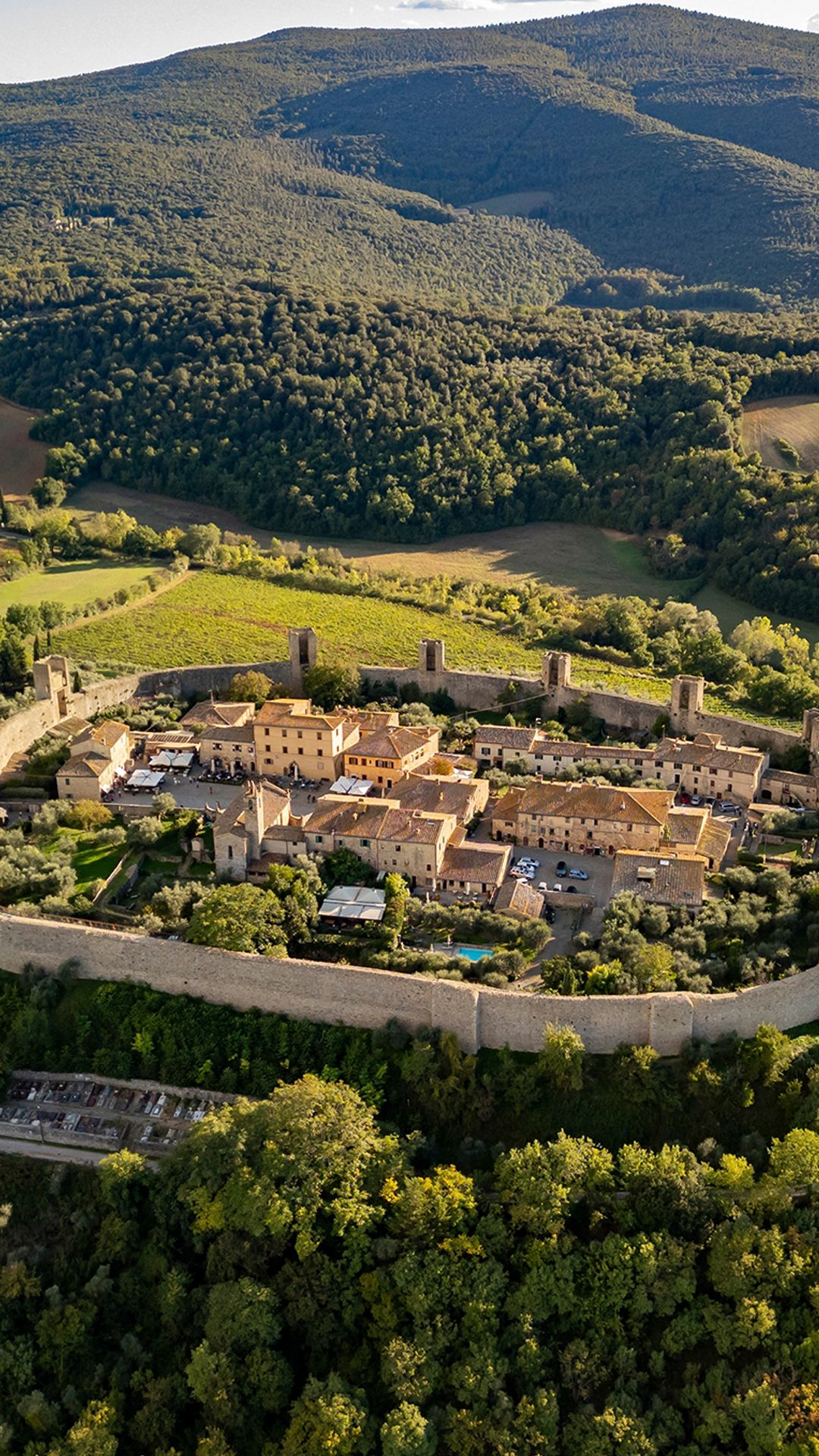 1080x1920 Medieval walled town aerial view with countryside and fields, Monteriggioni, Tuscany, Italy. Windows Spotlight Image