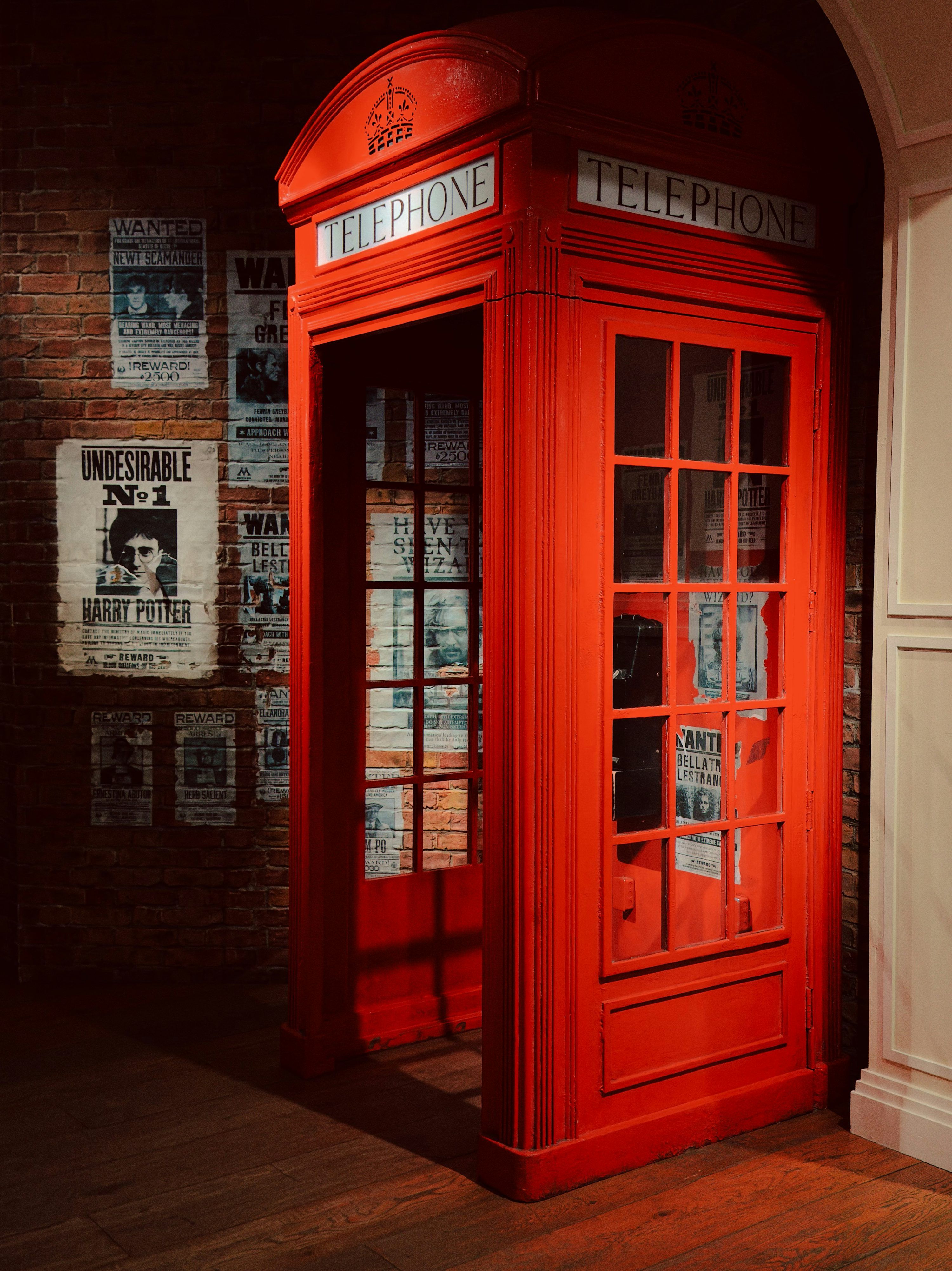 3000x4005 A vintage red british telephone booth with posters on wall