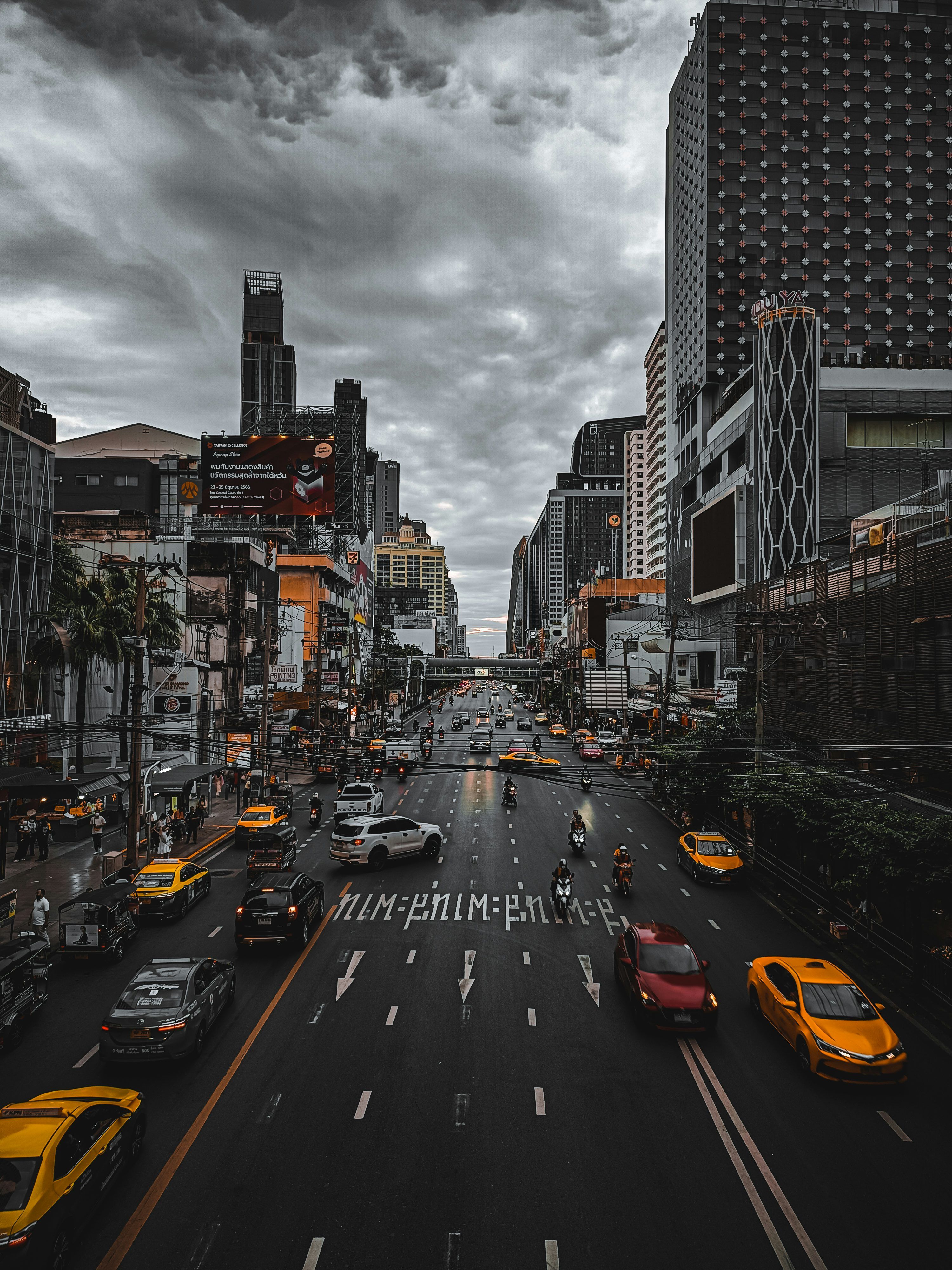 3000x4000 A city street filled with lots of traffic under a cloudy sky