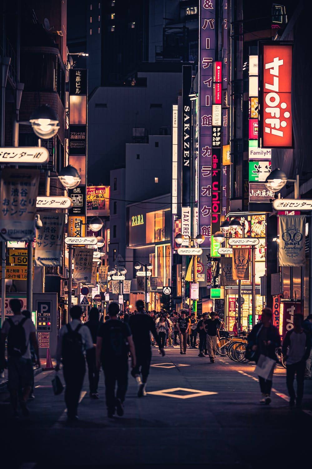1000x1500 Download Vibrant Nightlife in the Bustling Night City Wallpaper