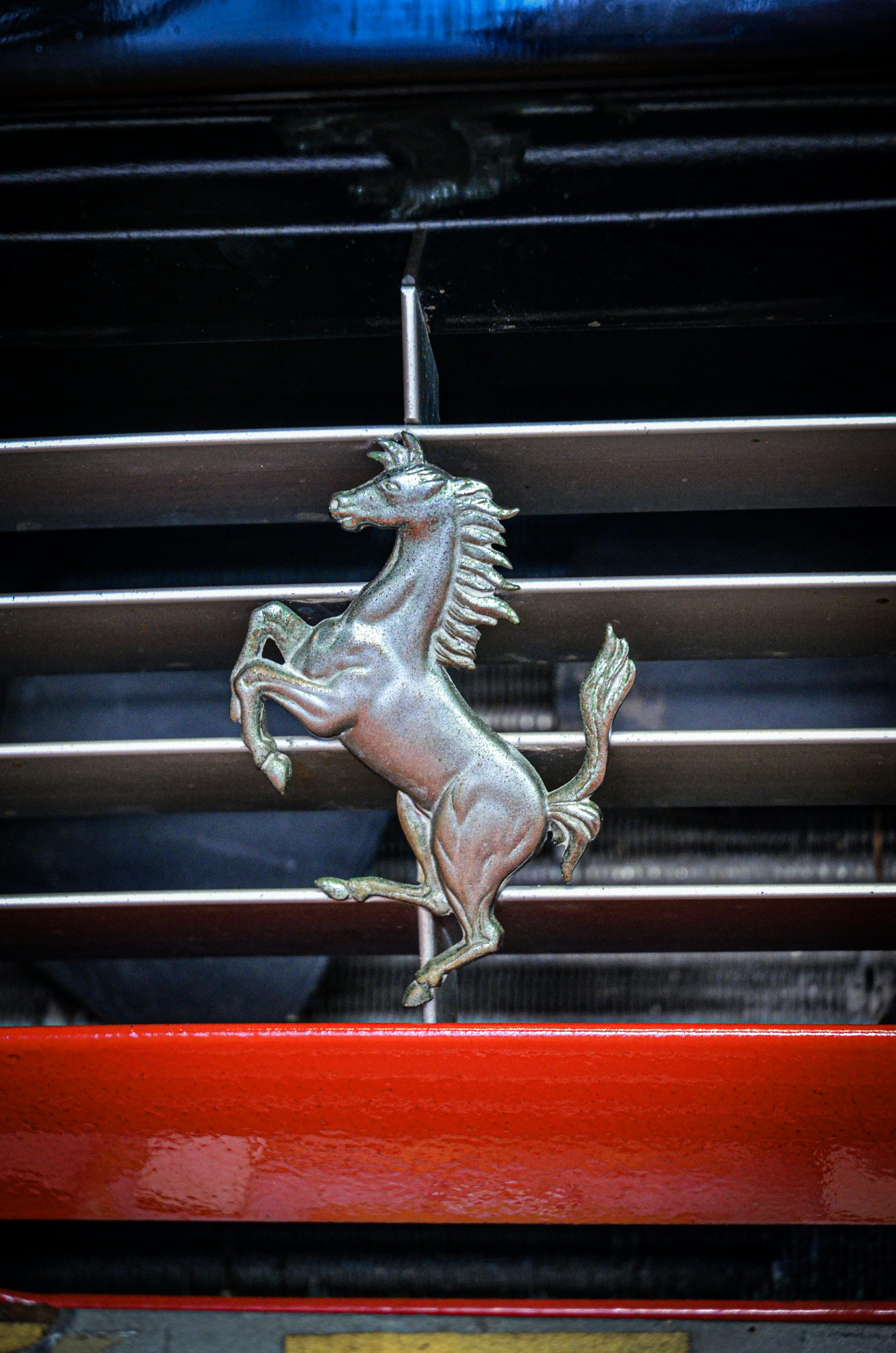 3000x4528 A metal horse on the grill of a car