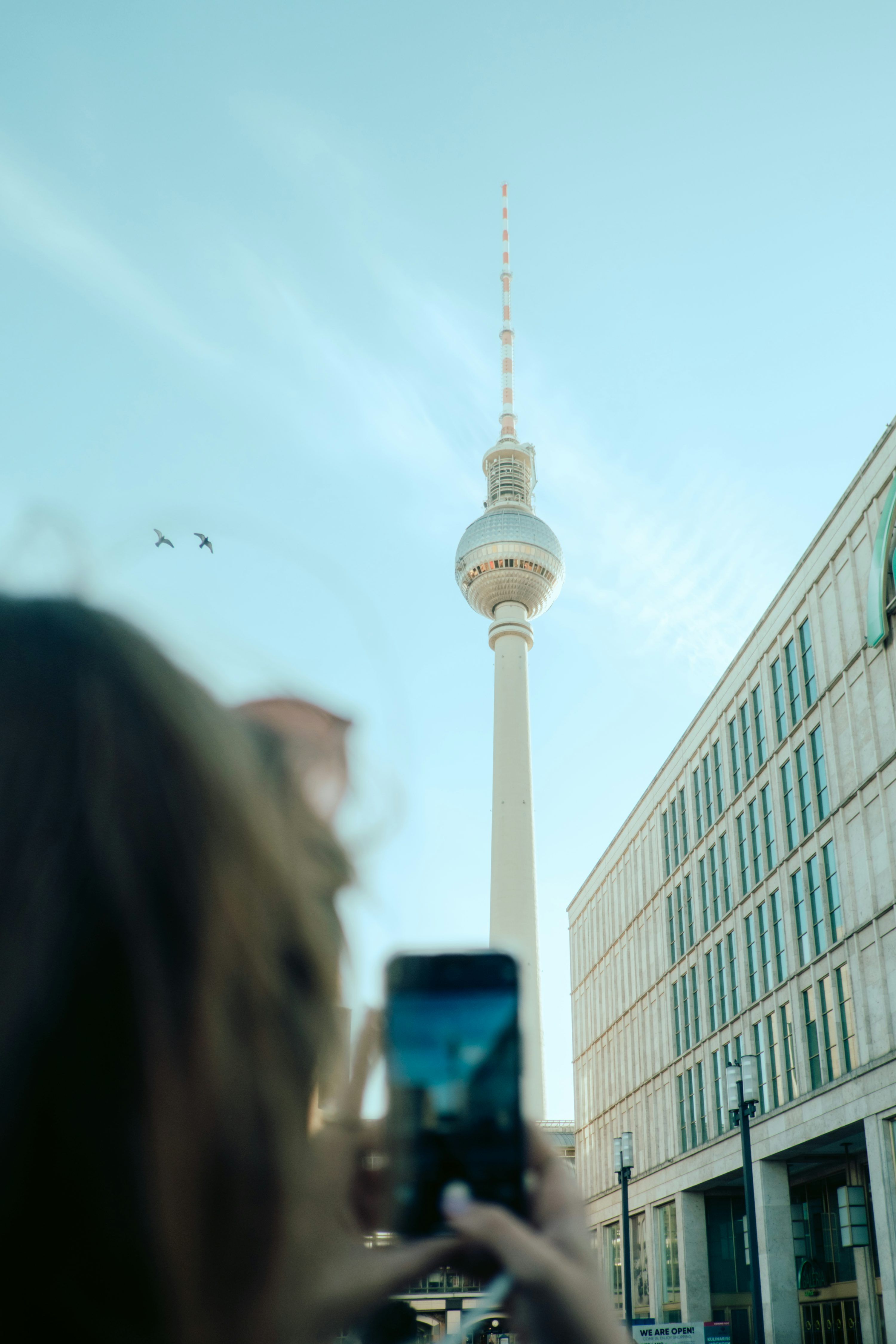 3000x4500 A woman taking a picture of the tv tower