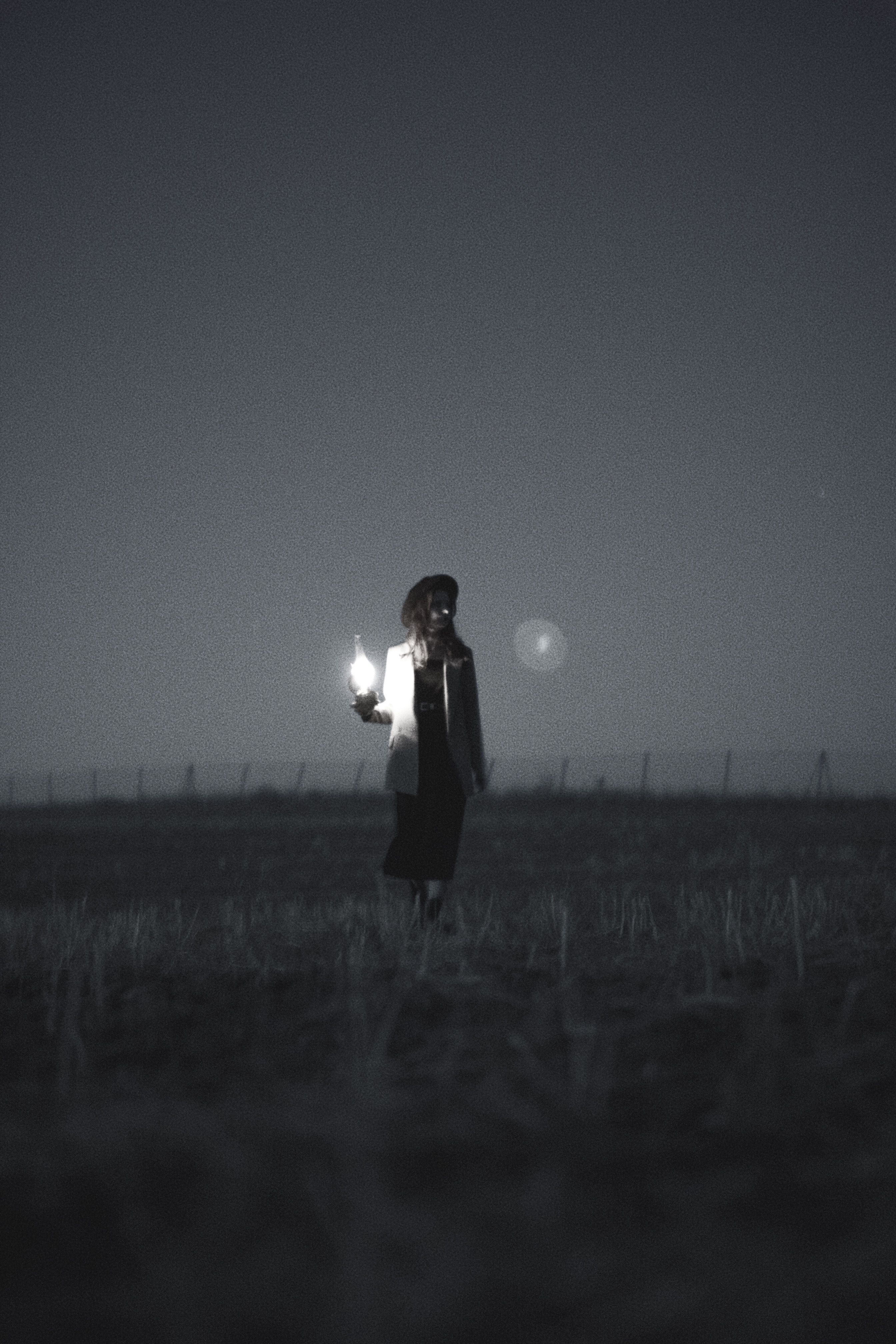 2688x4032 Woman Holding a Lamp on a Field in Black and White · Free