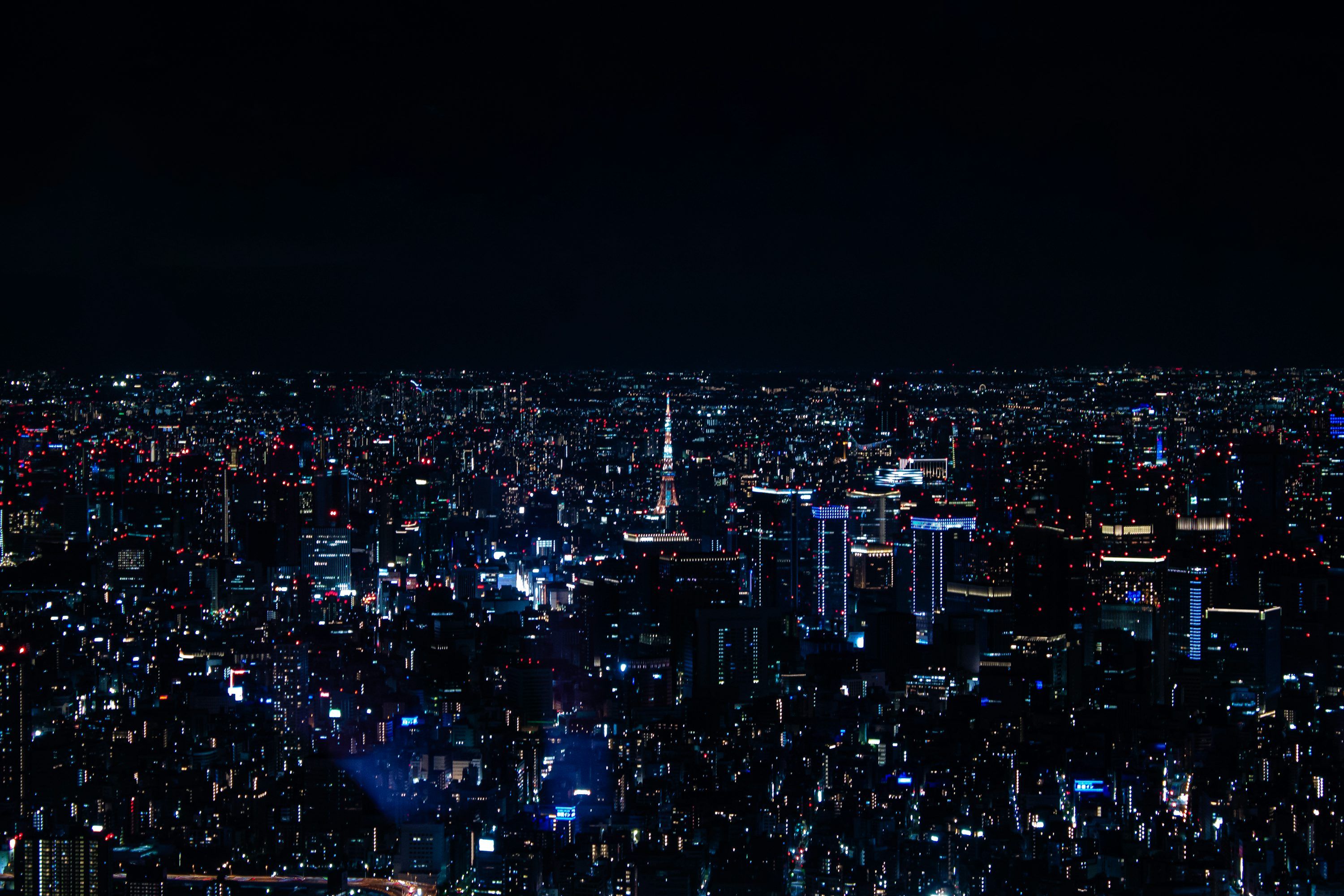 3000x2000 A view of a city at night from the top of a building