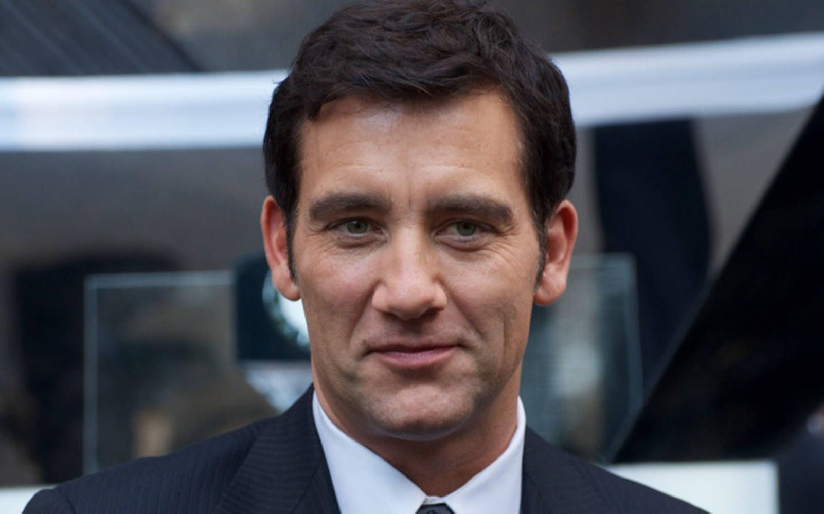 1602x1000 Download Charismatic Clive Owen Smiling Wallpaper
