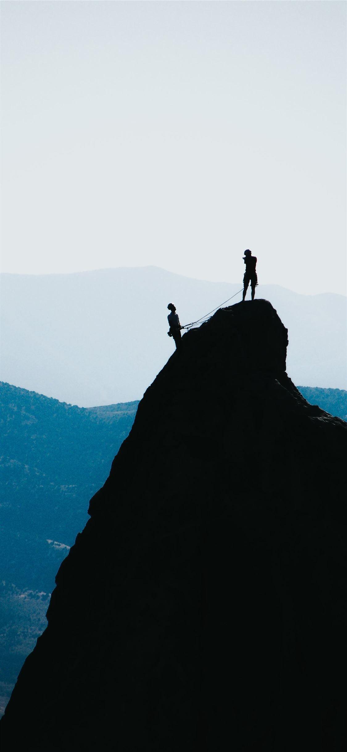 1125x2436 silhouette of two people standing on mountain duri. #iPhoneXWallpaper. Cool wallpaper for phones, Phone wallpaper image, Phone wallpaper