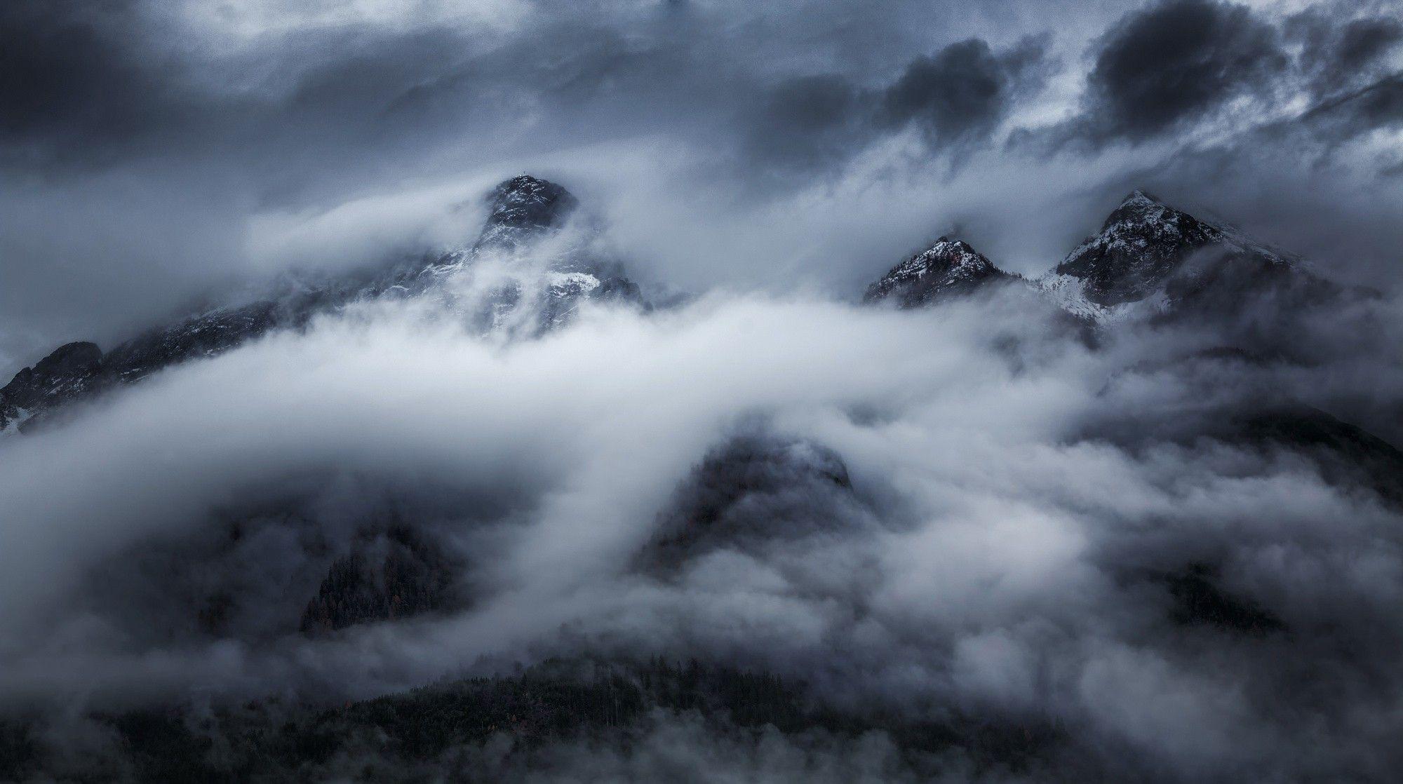 2000x1118 nature landscape clouds mountains dark storm snowy peak trees forest mist wallpaper