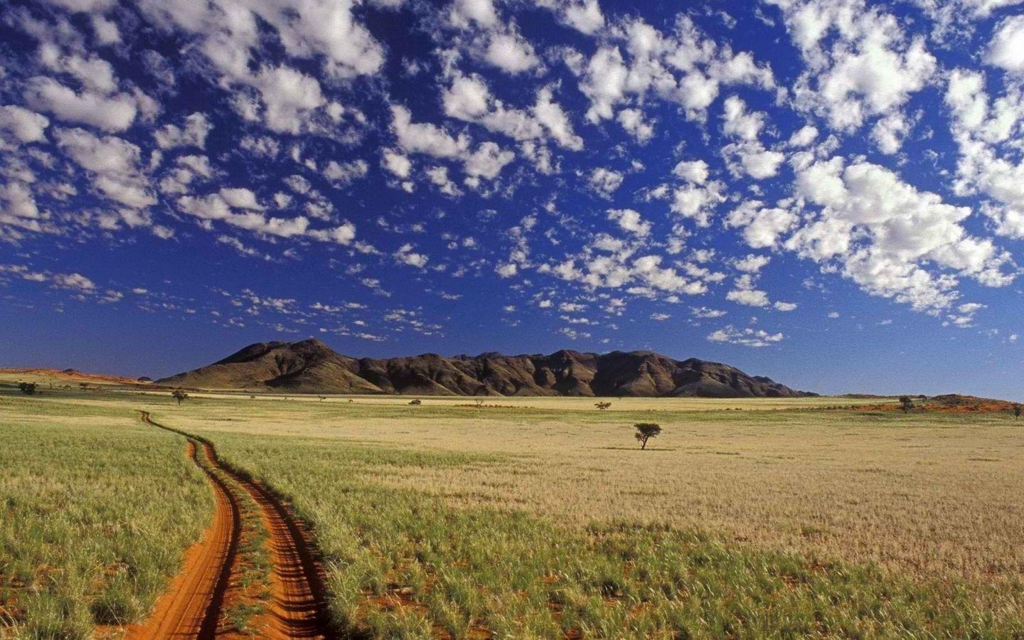 1440x900 Download wallpaper 1440x900 road, dirt, prairie, clouds, sky widescreen 16:10 HD background