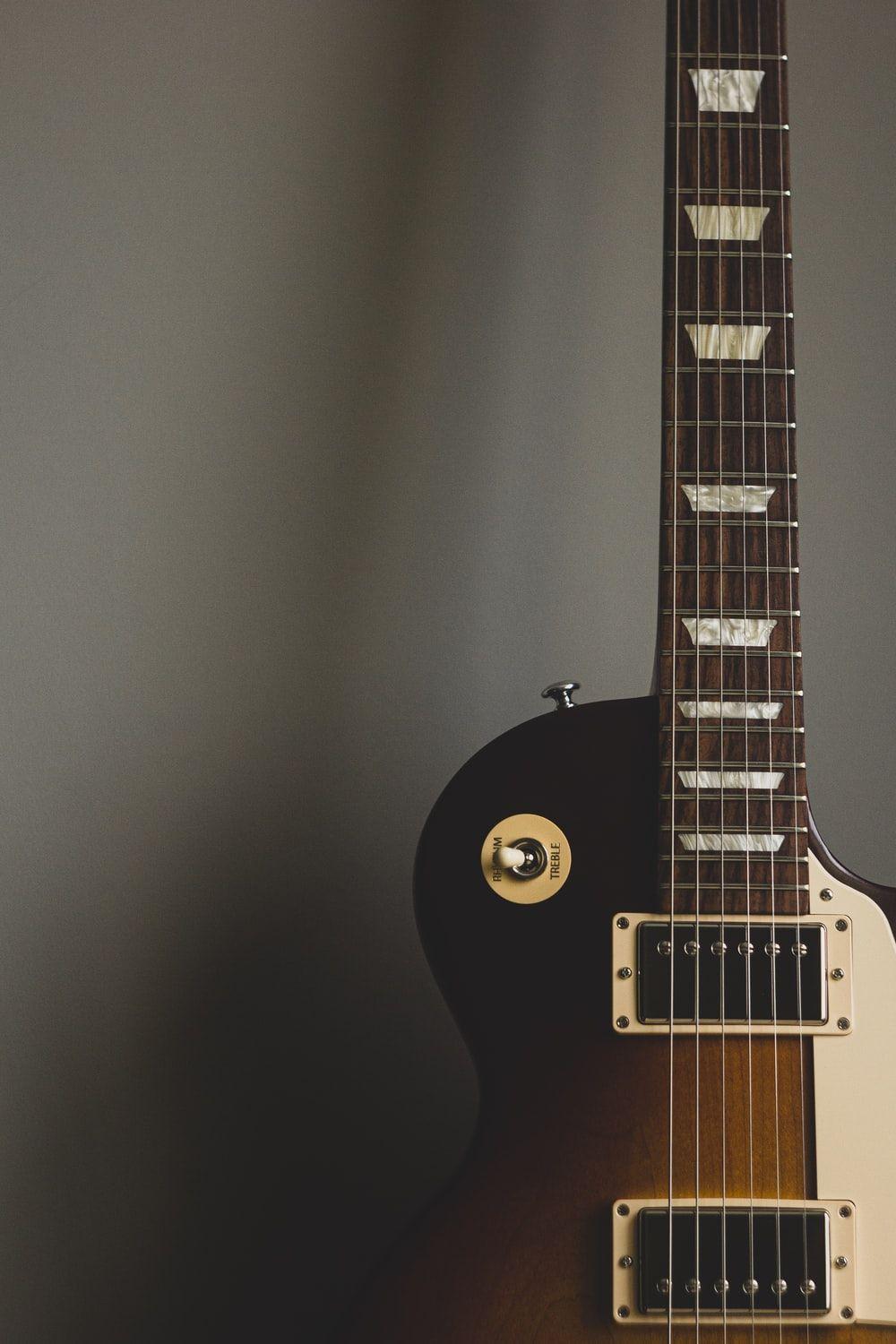 1000x1500 black electric guitar on black wall photo