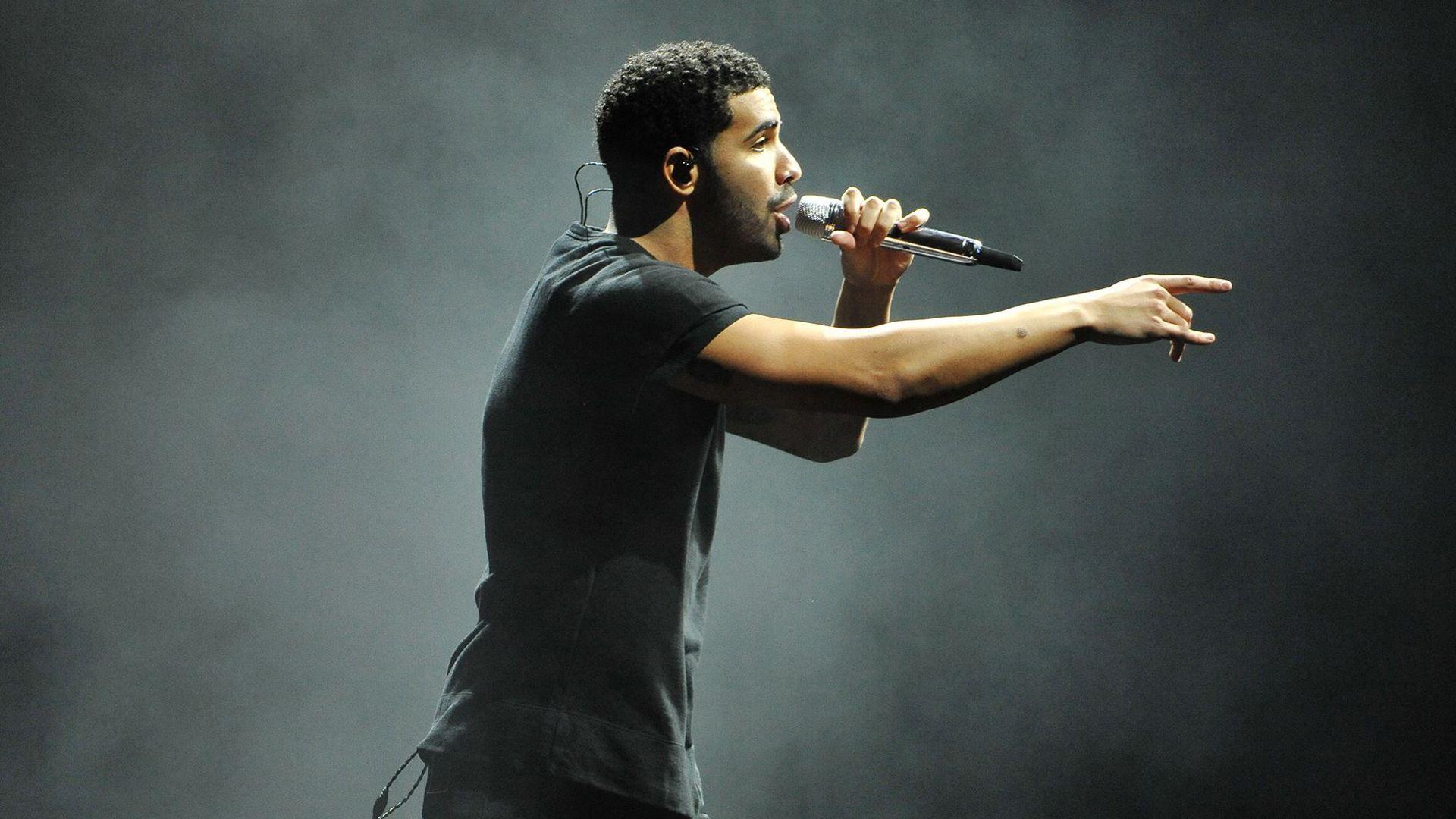 1920x1080 Drake Is Holding Mike Facing One Side Wearing Black Dress In Fog Background HD Drake Wallpaper