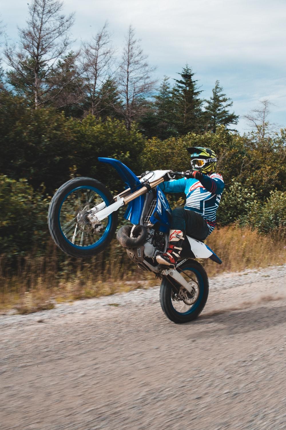 1000x1500 man in white and blue racing suit riding blue motocross dirt bike photo