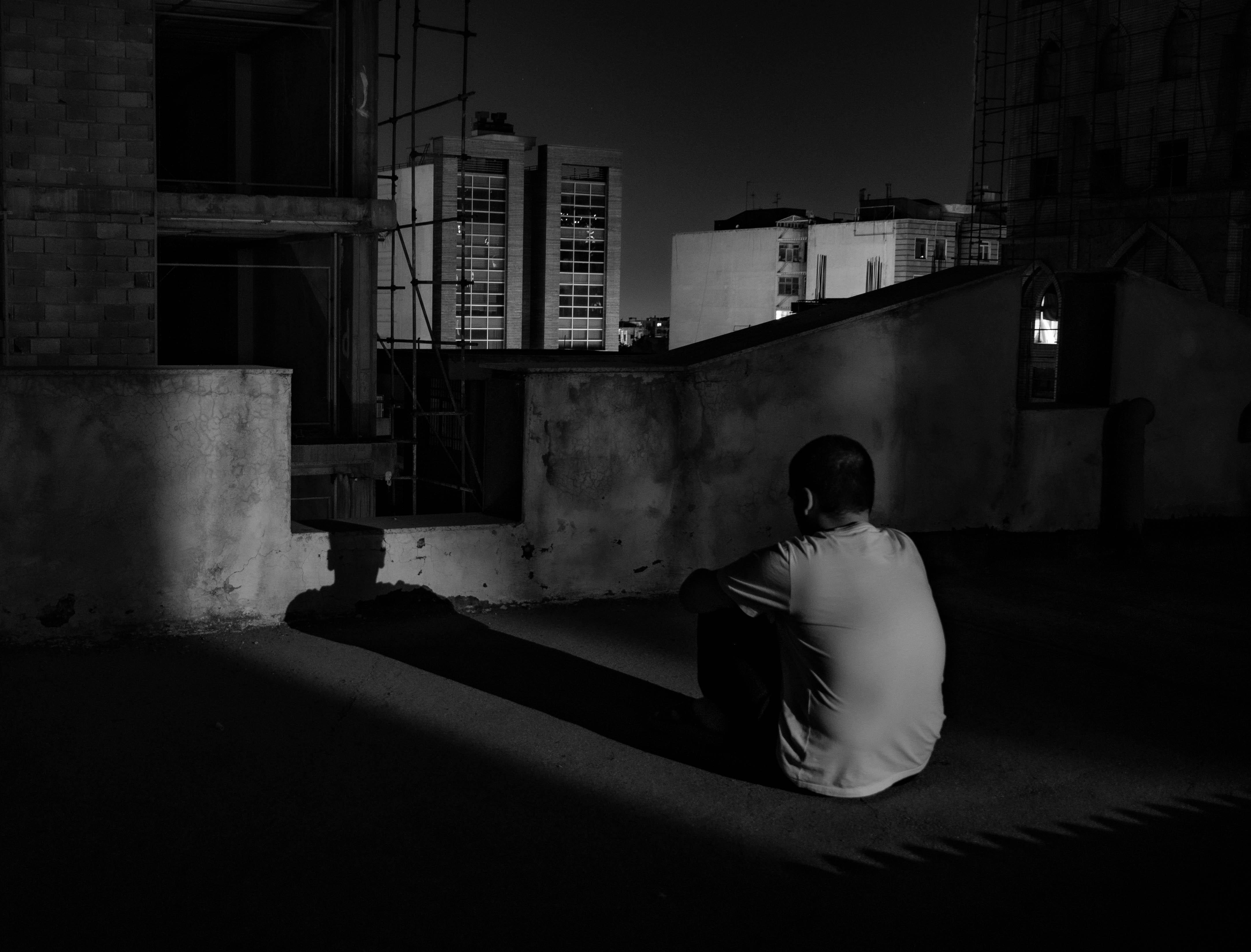 4332x3296 Lonely man sitting on rooftop at night · Free