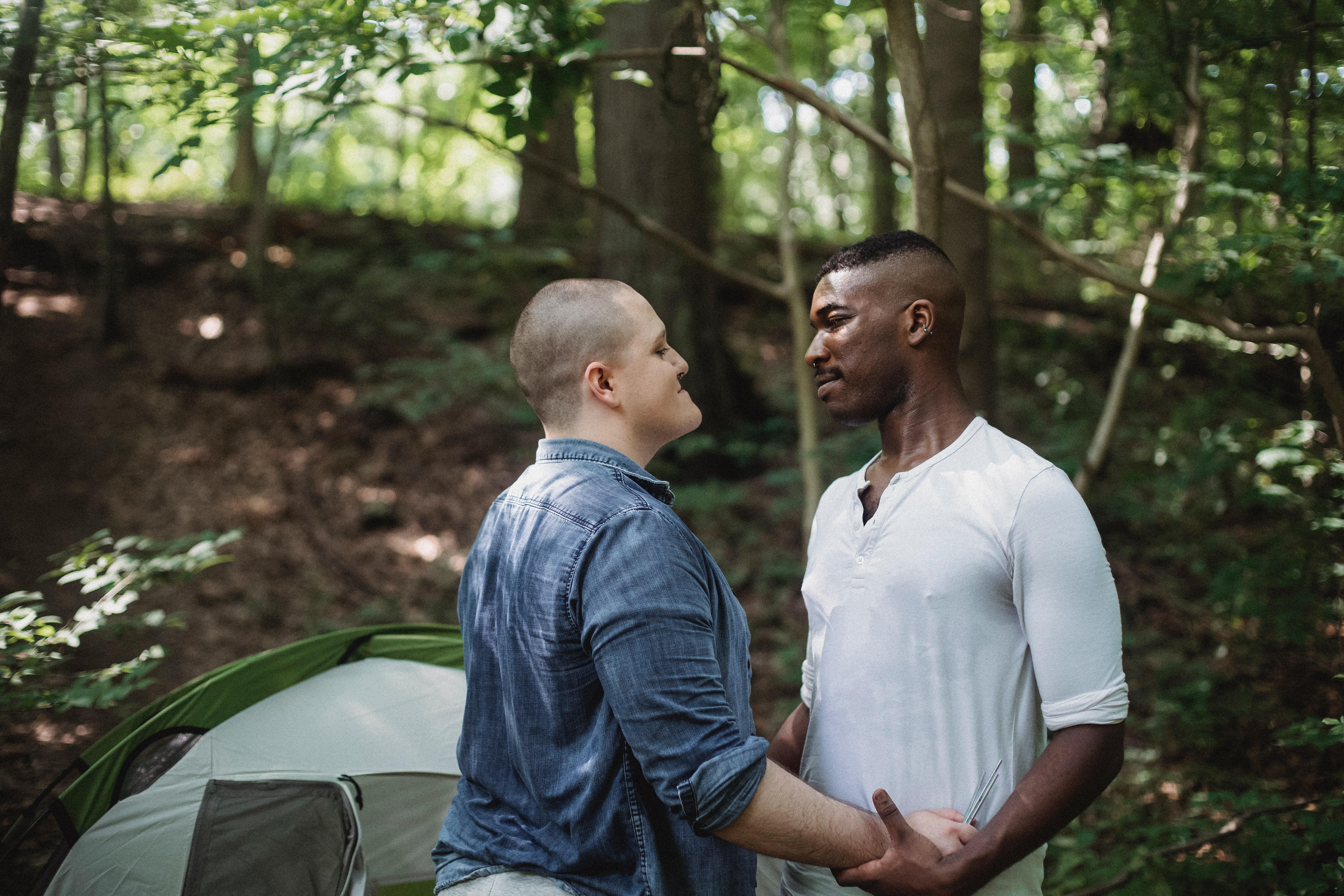6000x4000 Happy gay couple embracing near tent during forest trip · Free