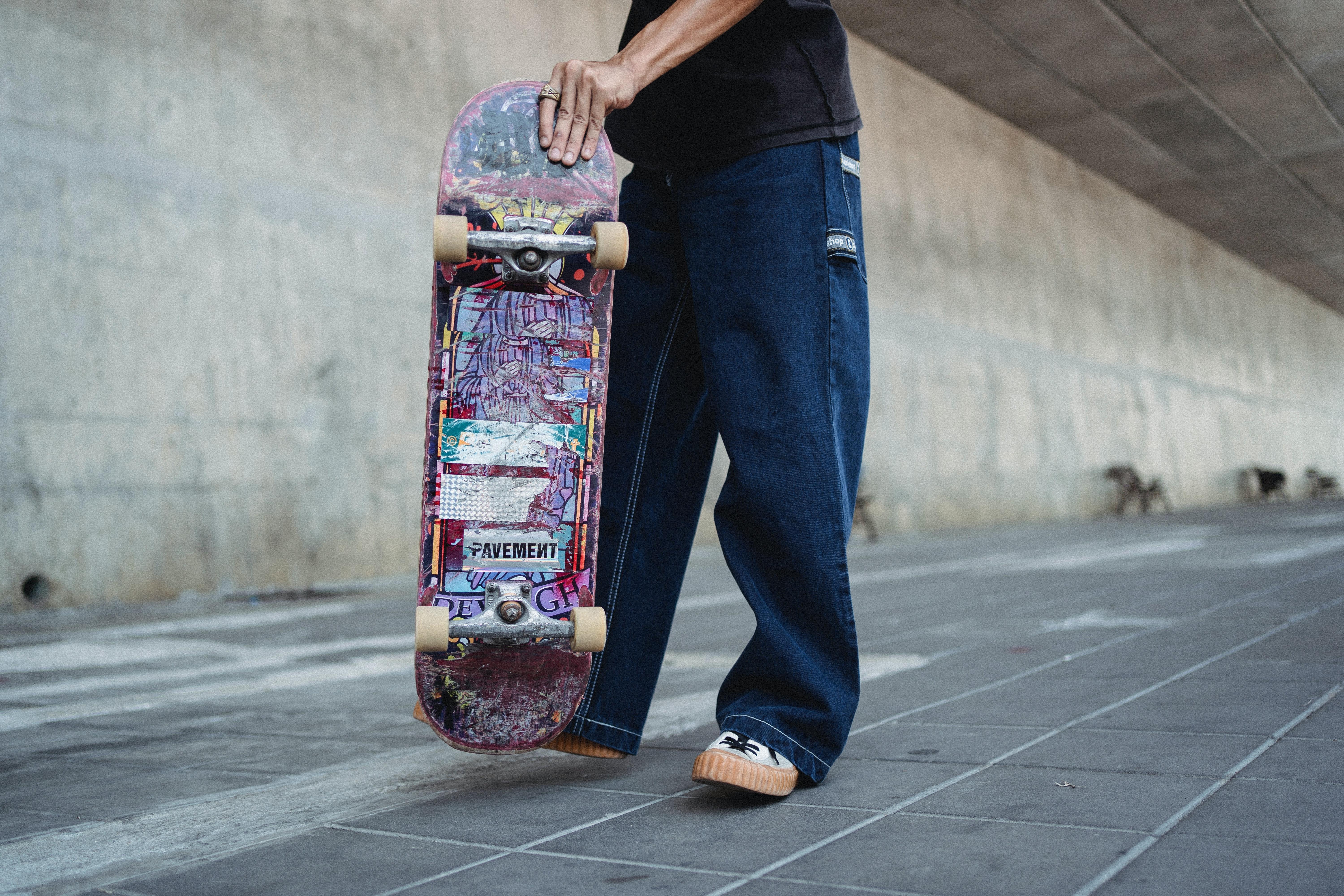 6000x4000 Crop faceless skater standing with longboard on sidewalk · Free