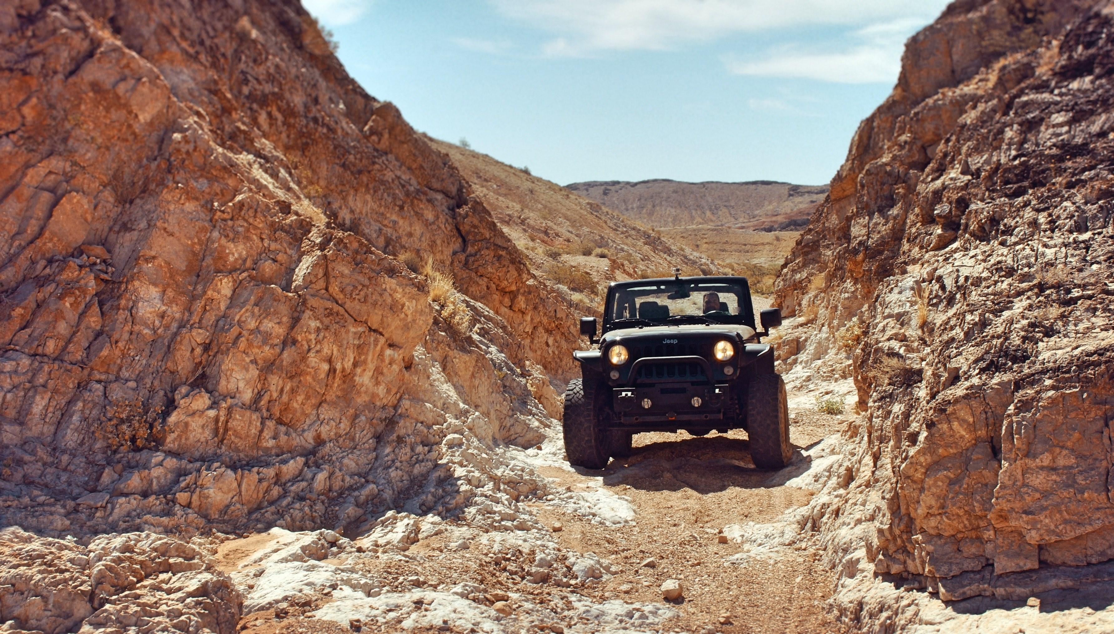 3568x2033 Wallpaper / jeep truck drives through rough terrains in a desert canyon in nevada, black jeep nevada desert 4k wallpaper