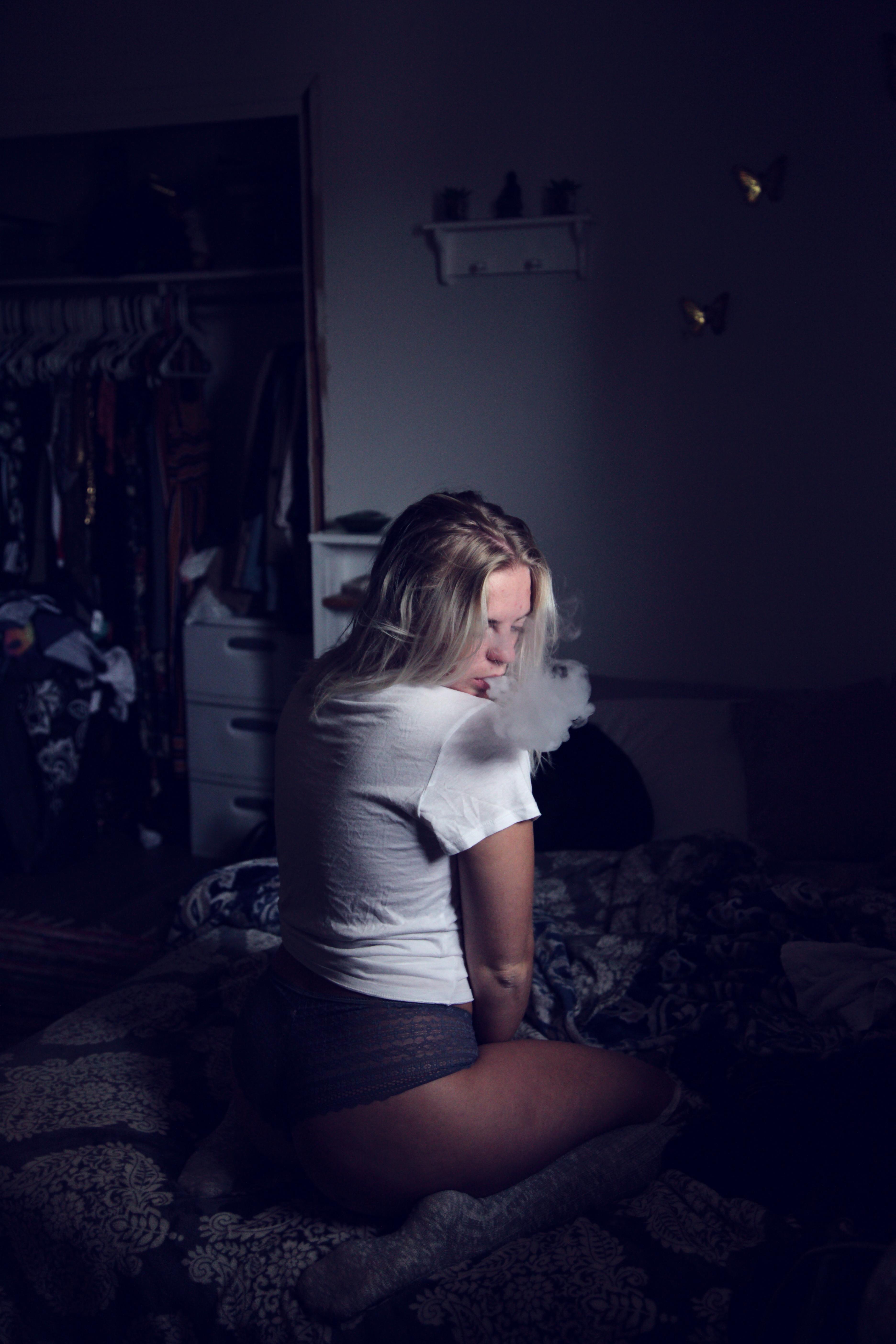 3744x5616 Woman Wearing White Shirt Sitting on Sofa and Smoking · Free