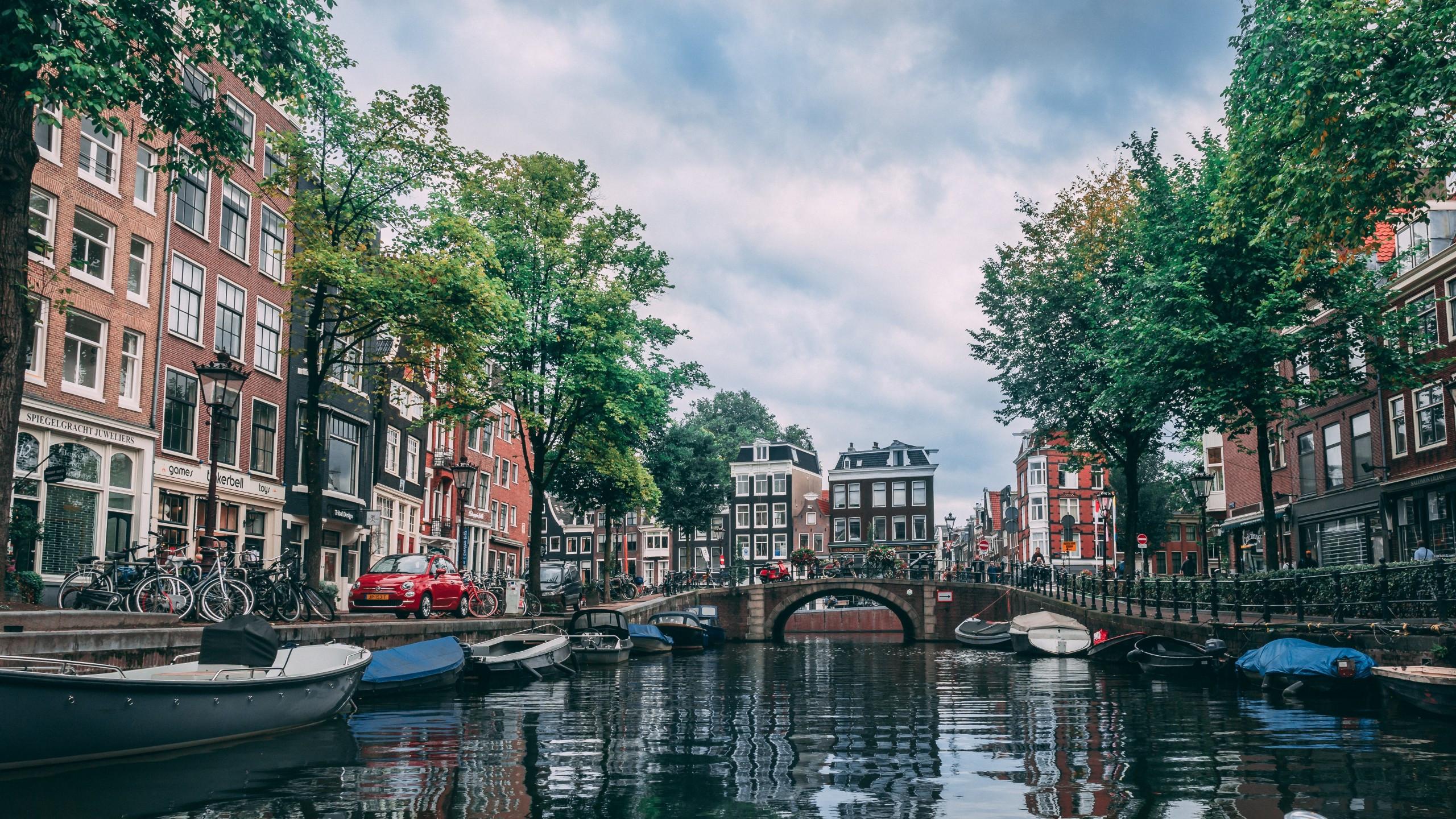 2560x1440 Download 2560x1440 Canal, Amsterdam, Germany, Buildings, Trees, Boats, Urban Wallpaper for iMac 27 inch