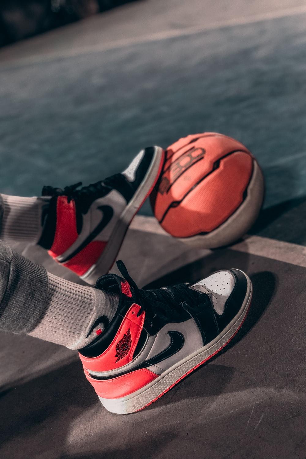 1000x1500 person wearing black and red nike basketball shoes photo