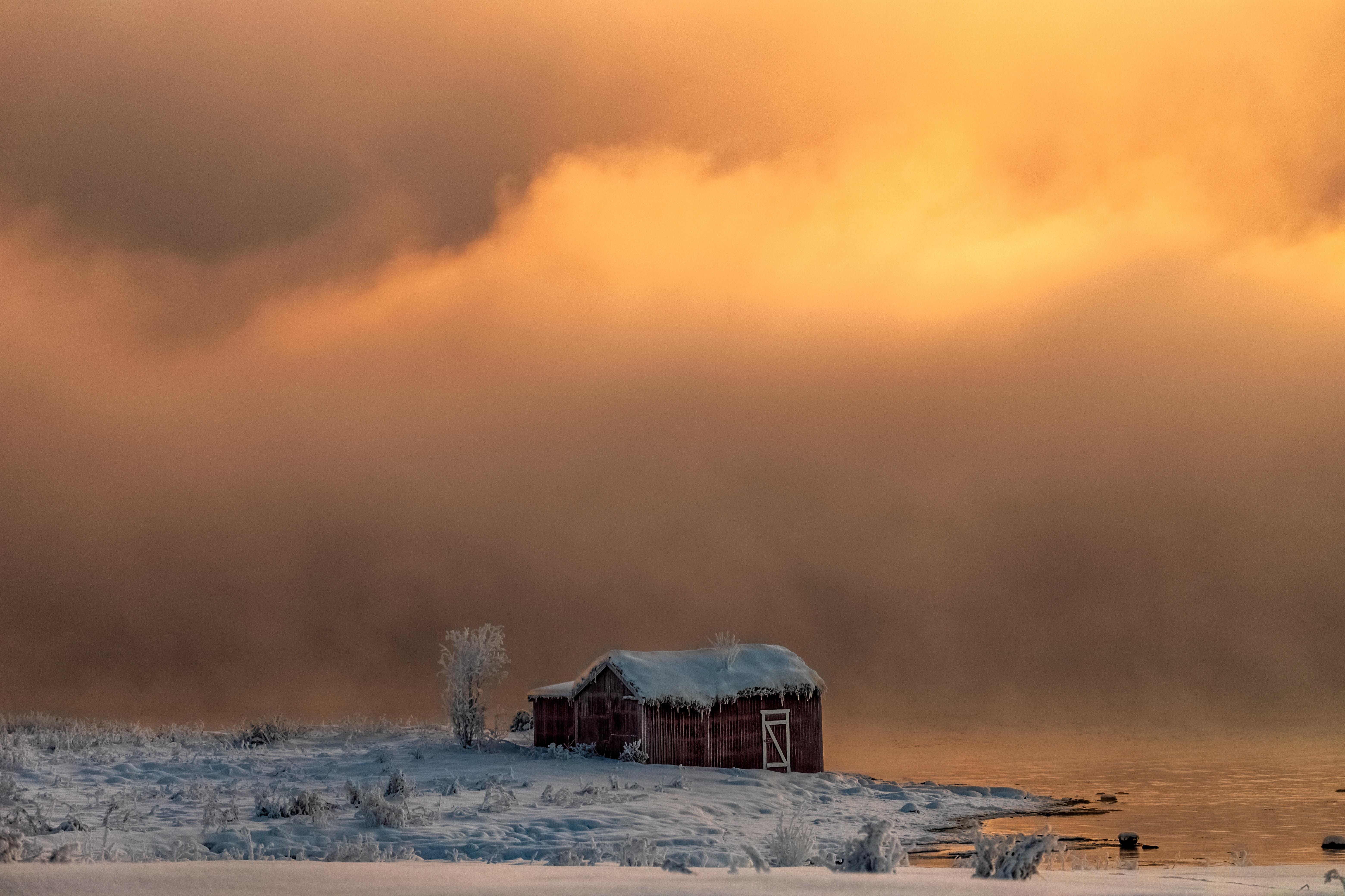 6240x4160 A Brown Barn Close To The River Under Cloudy Skies And Snow Covered Grounds In Winter · Free