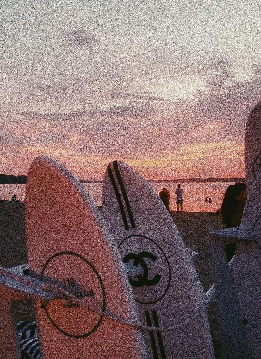 Free Photo  A surfer wearing surfing swimsuit holding a surfboard standing  at the seashore during sunset