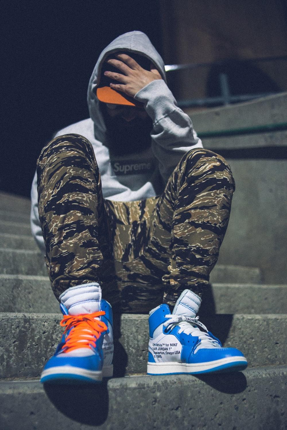 1000x1500 person in black and brown camouflage jacket and blue and white nike shoes photo