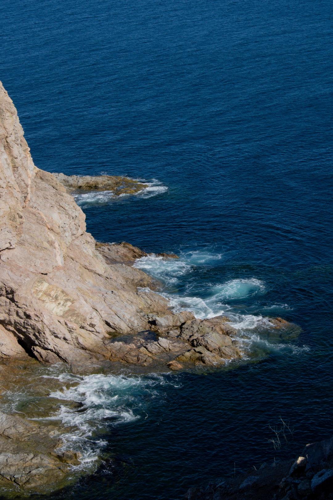 1080x1620 brown rocky mountain beside blue sea during daytime photo