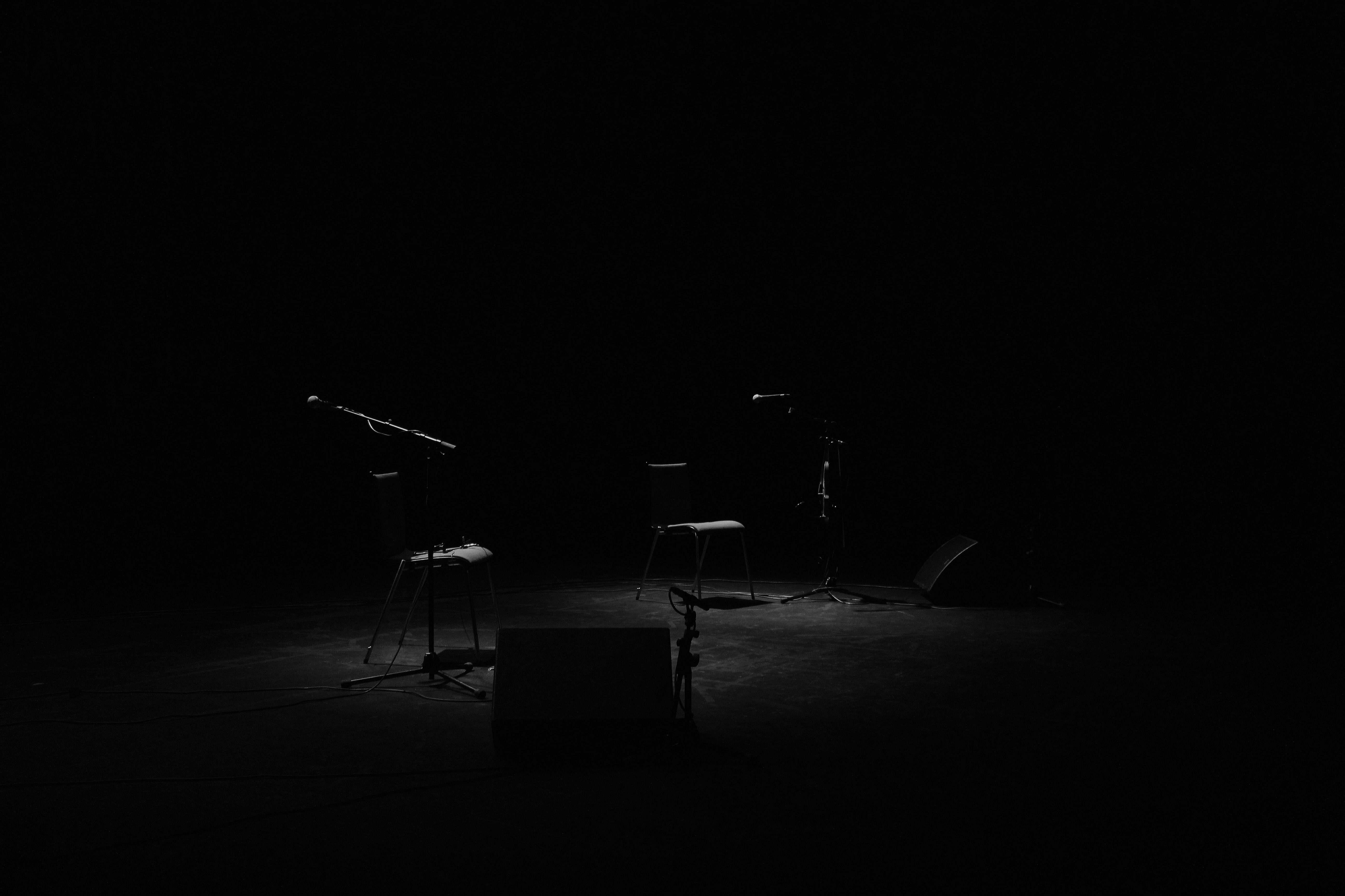 5184x3456 Black And White A Dim Shot Of Two Chairs And Microphone Stands On An Empty Stage Music Image