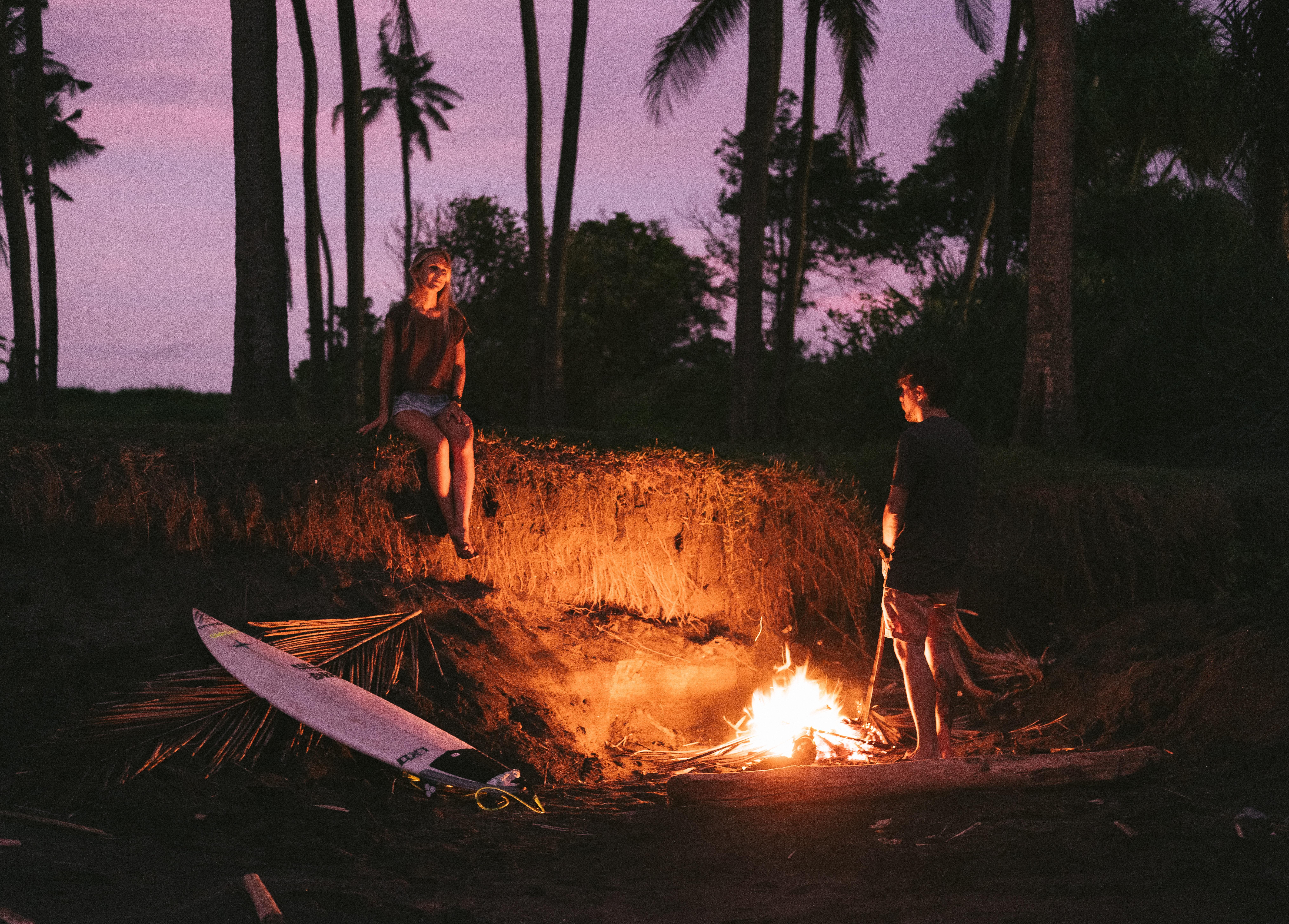 8121x5822 Romantic couple having date on beach near bonfire during sundown · Free