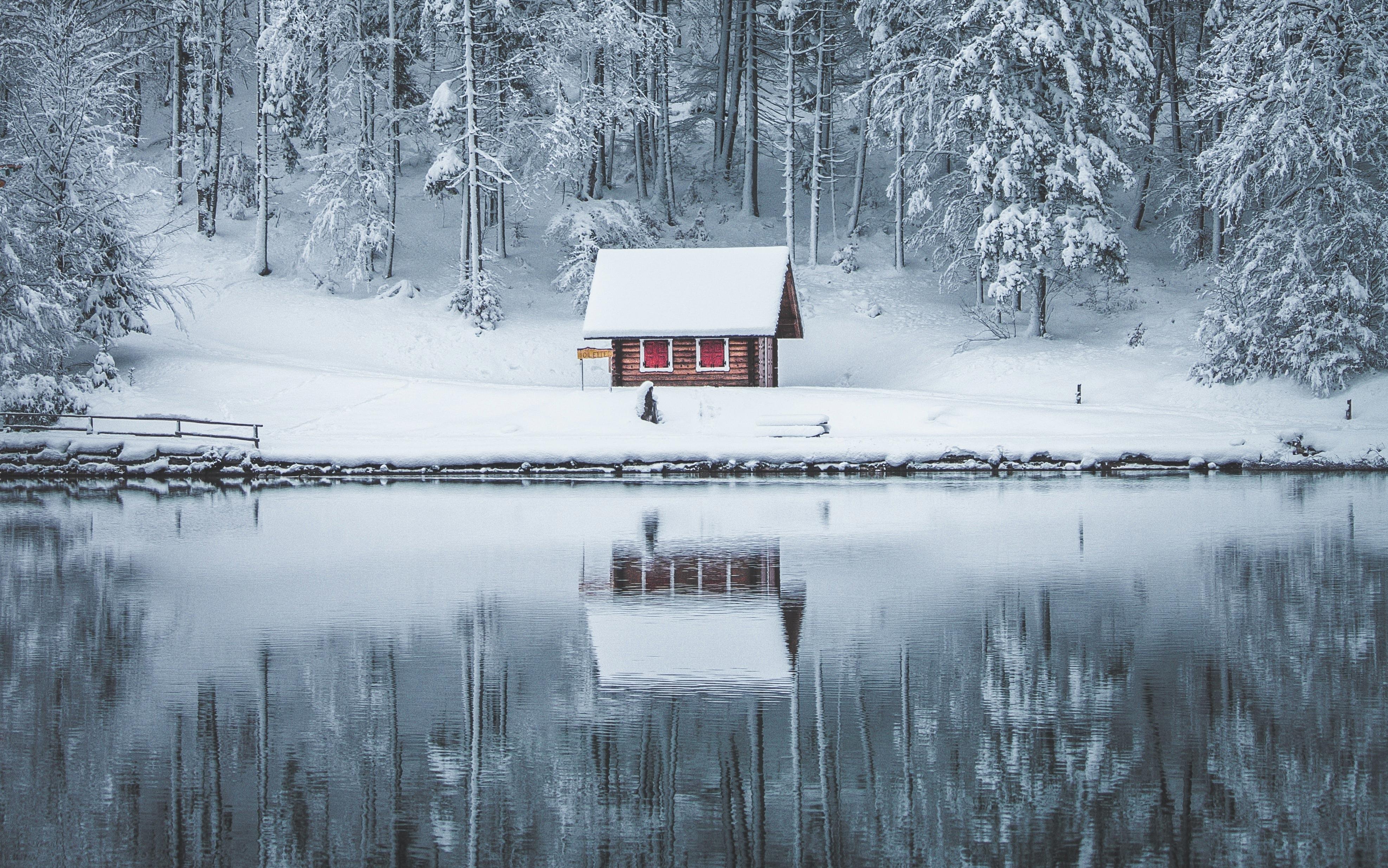 3949x2471 Small cabin in the woods near a lake after a snowfall 4k Ultra HD Wallpaper