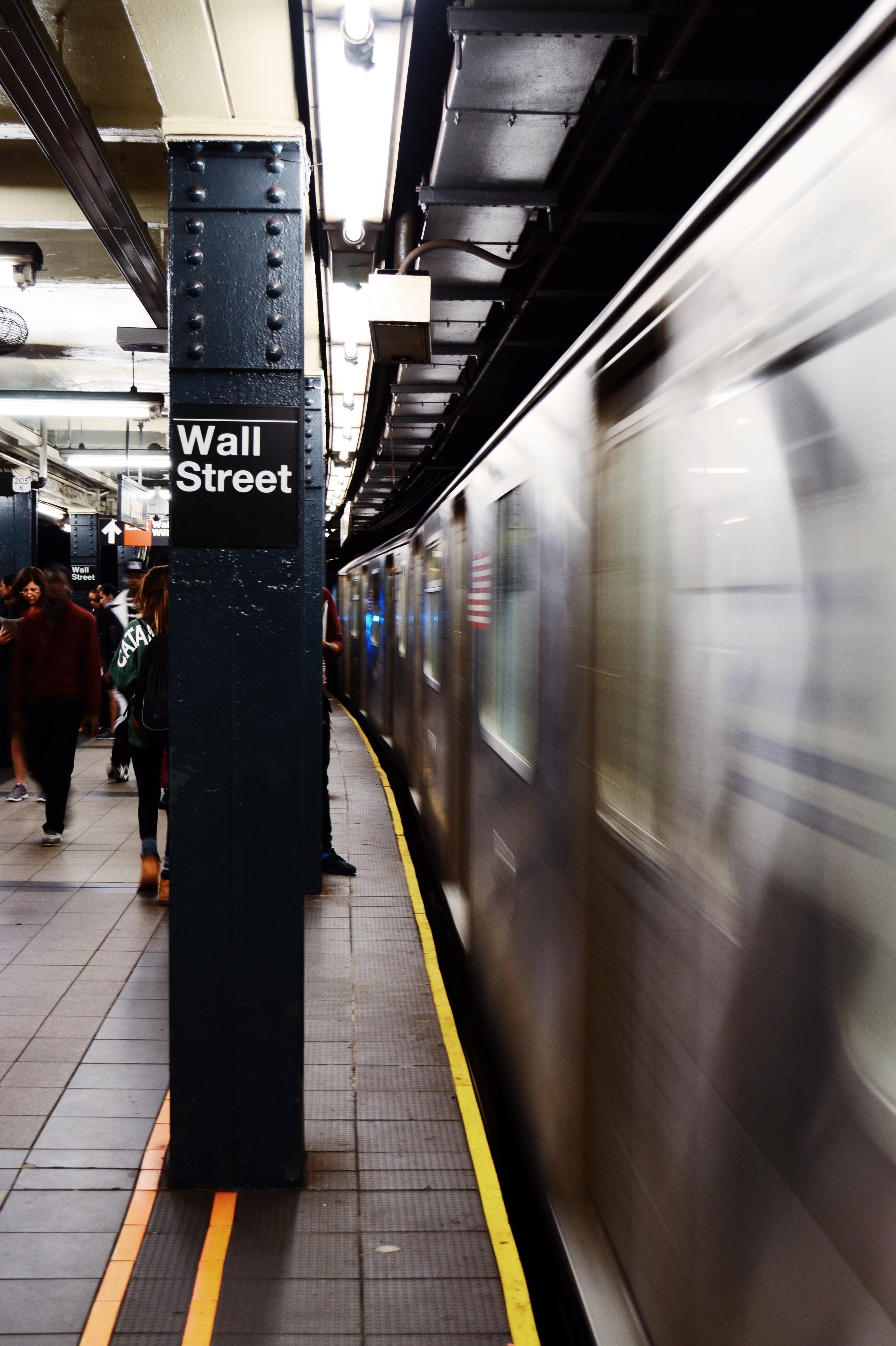 3177x4770 Wallpaper / a moving train at the platform of the wall street subway station in new york, wall street subway station 4k wallpaper