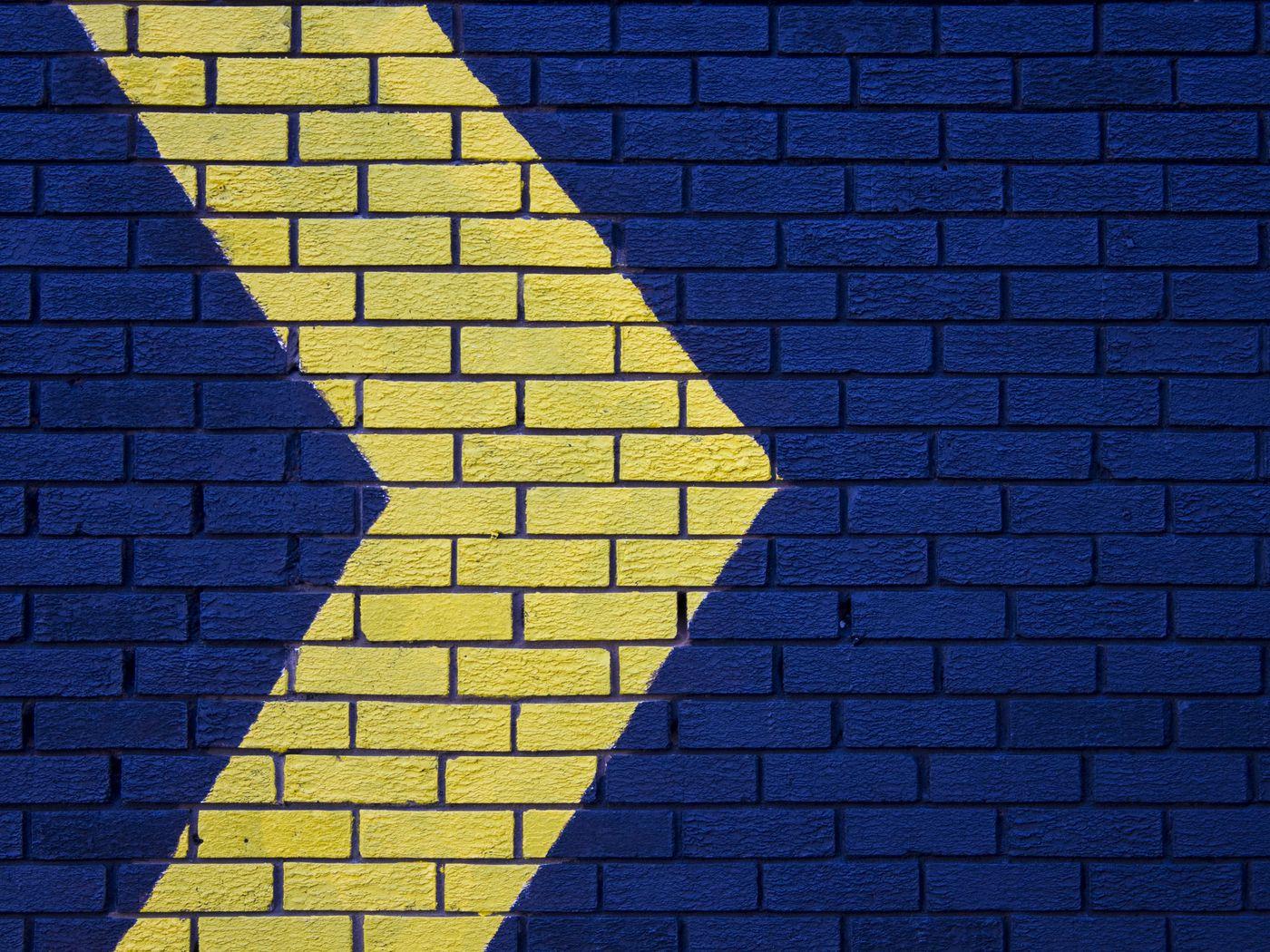 1400x1050 Download wallpaper 1400x1050 wall, brick, arrow, blue, yellow, pointer, direction standard 4:3 HD background