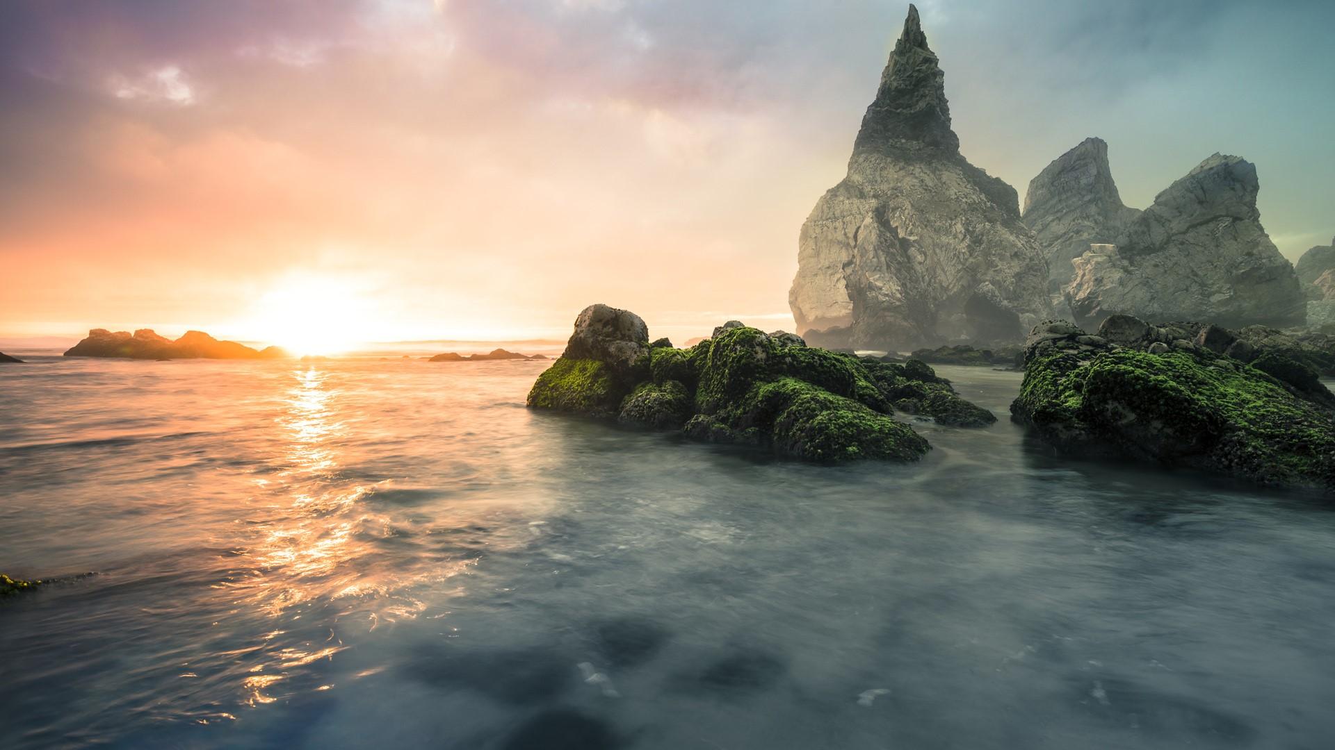1920x1080 Stone formations at Praia Ursa beach against the morning sun, Sintra, Portugal. Windows 10 Spotlight Image