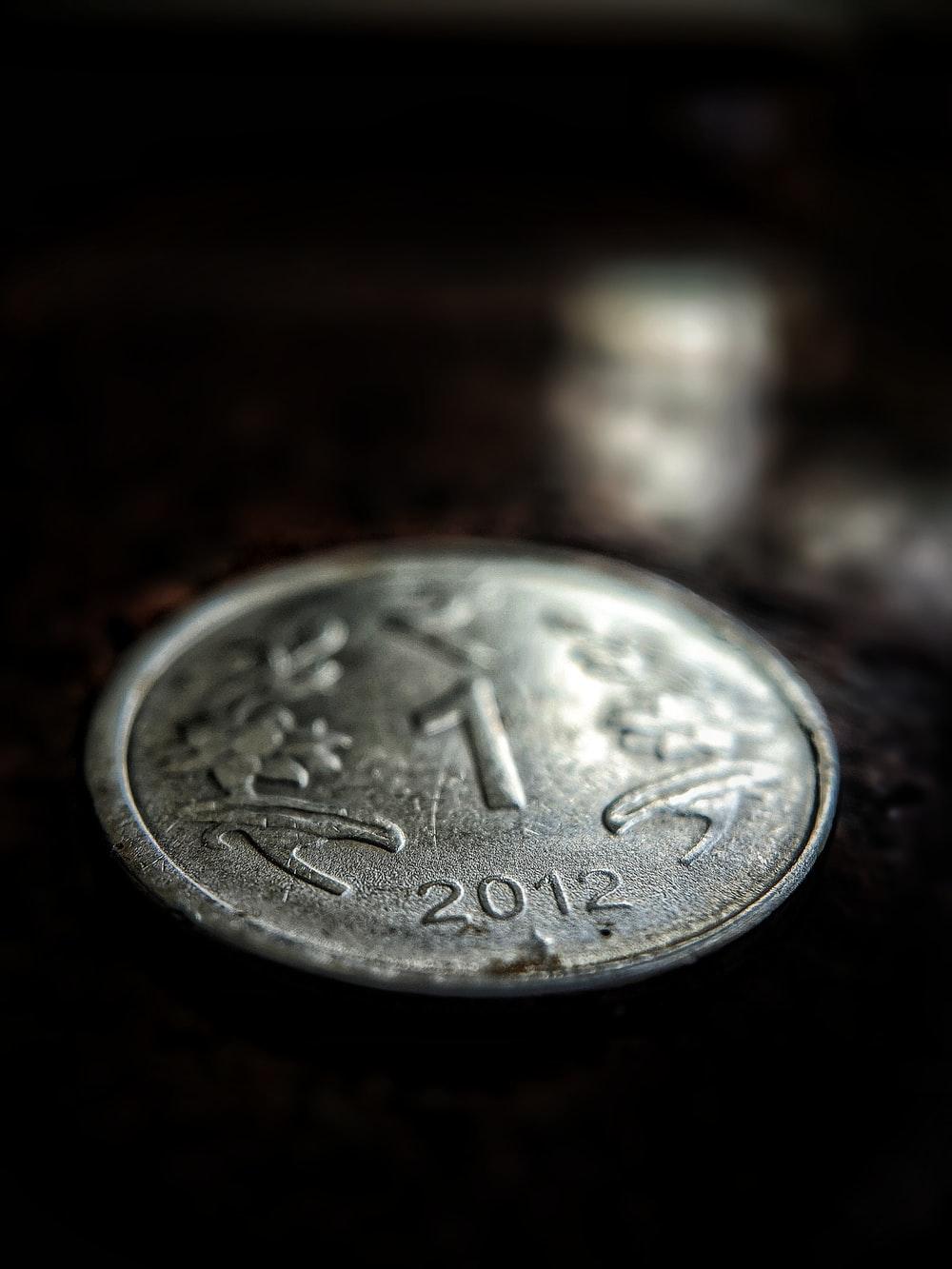 1000x1333 silver round coin on brown surface photo