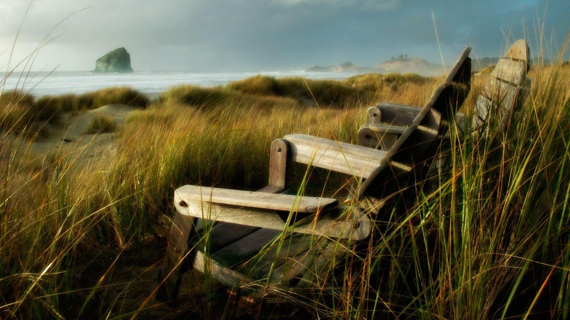 1920x1080 figure nic chairs grass field the wind shore coast rock stone sea overcast tall grass nature landscape HD wallpaper
