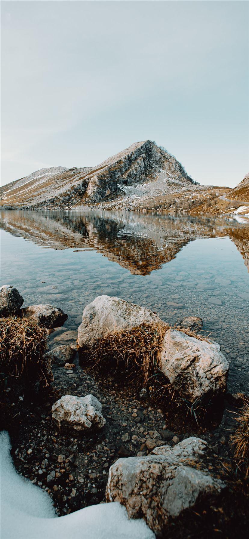 828x1792 brown rocky mountain beside lake under blue sky du. iPhone 11 Wallpaper Free Download