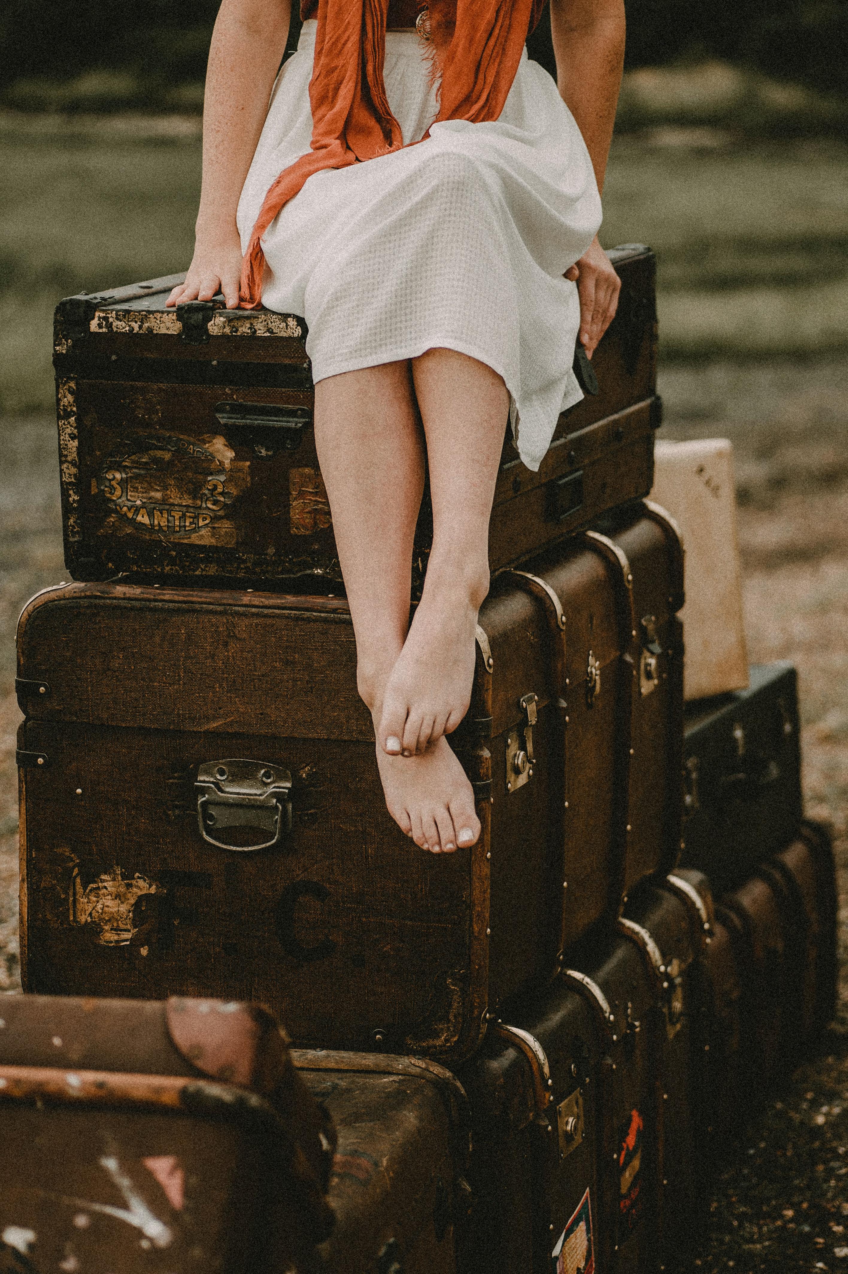 2833x4256 Crop stylish woman sitting on retro trunks and suitcases · Free