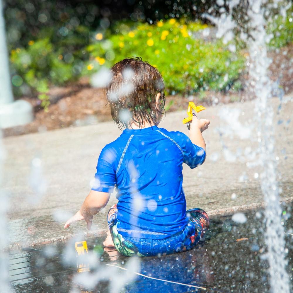 1000x1000 Boy In Blue T Shirt Playing With Water Photo