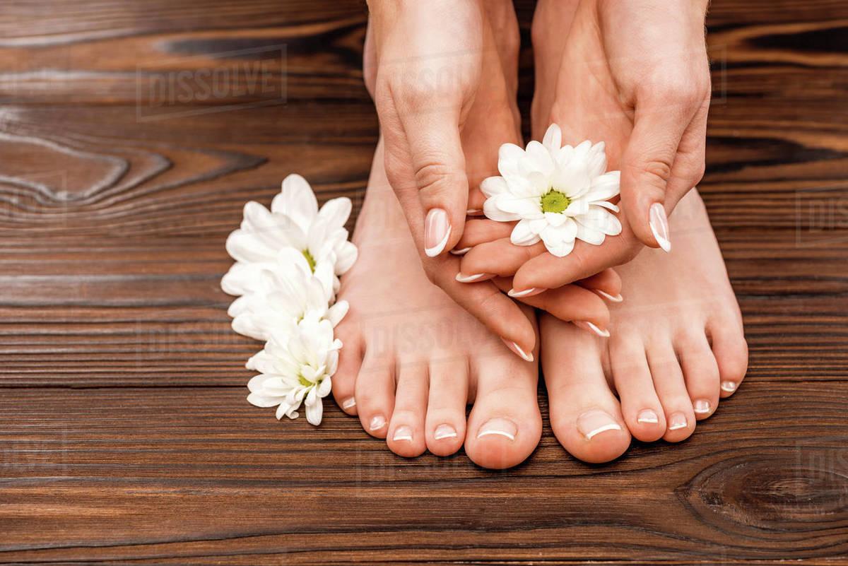 1200x801 Cropped view of female hands and feet with medicine and pedicure on wooden surface