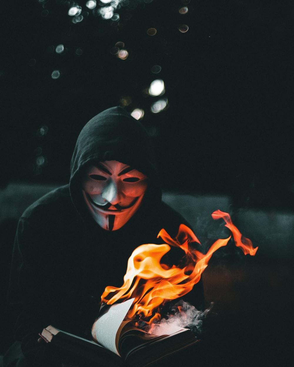1000x1250 person in black hoodie with orange flame in the background photo