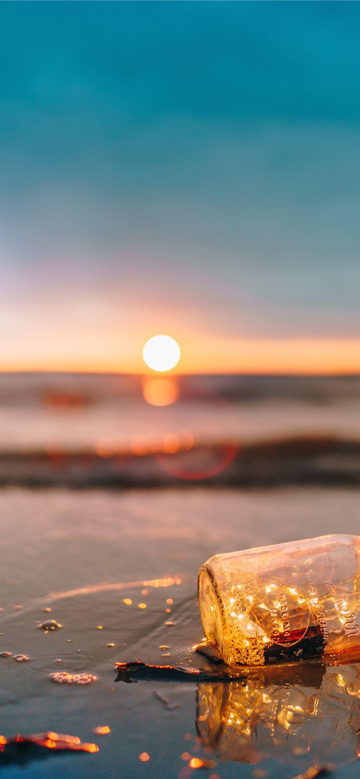 1170x2532 clear glass mason jar on beach during sunset iPhone 12 Wallpaper Free Download