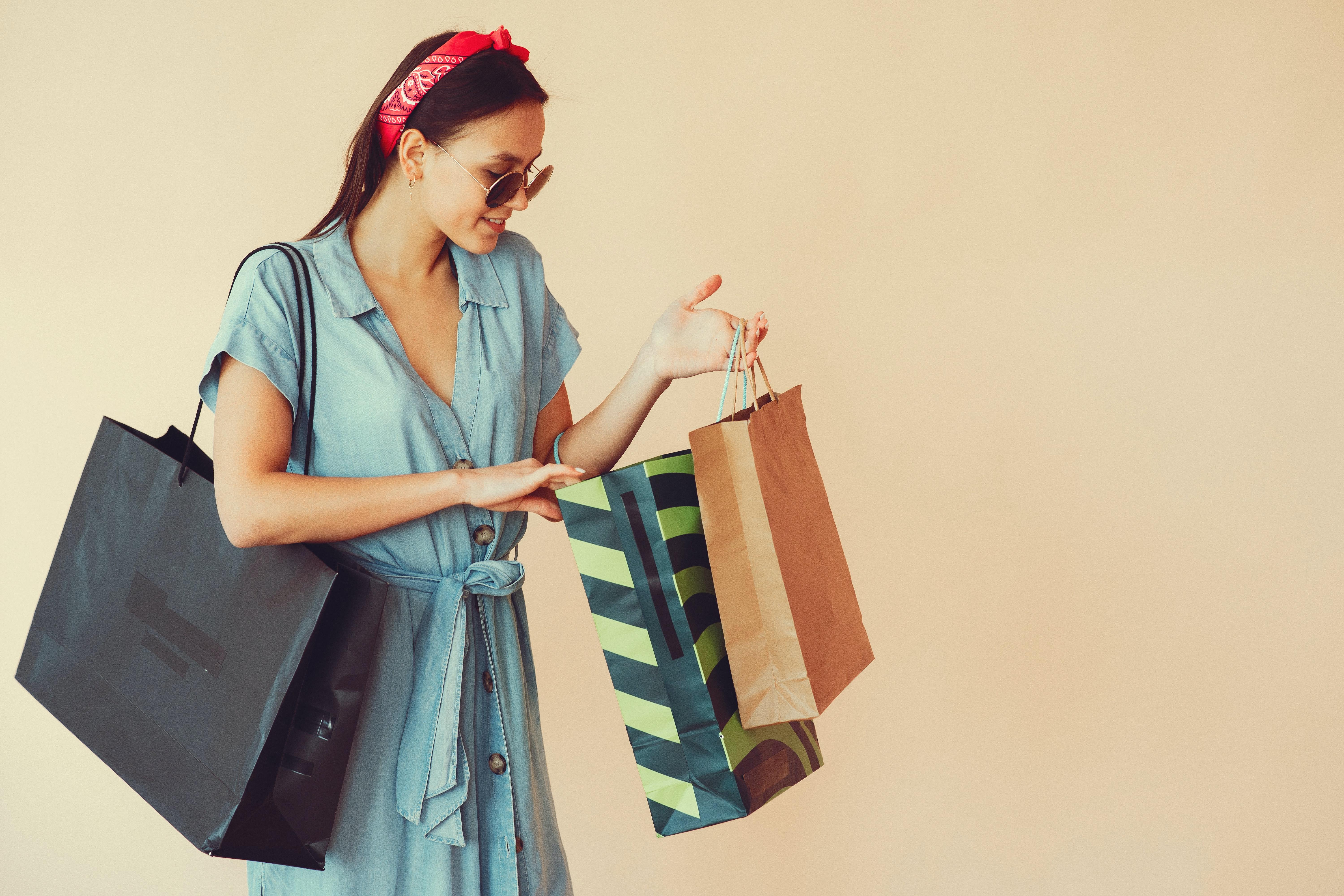 6000x4000 Happy young lady with shopping bags on beige background · Free